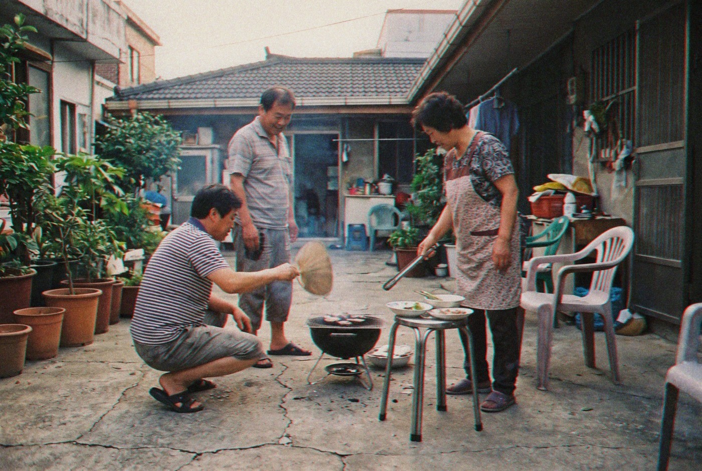 Illustration: A family grilling food in a shared courtyard
