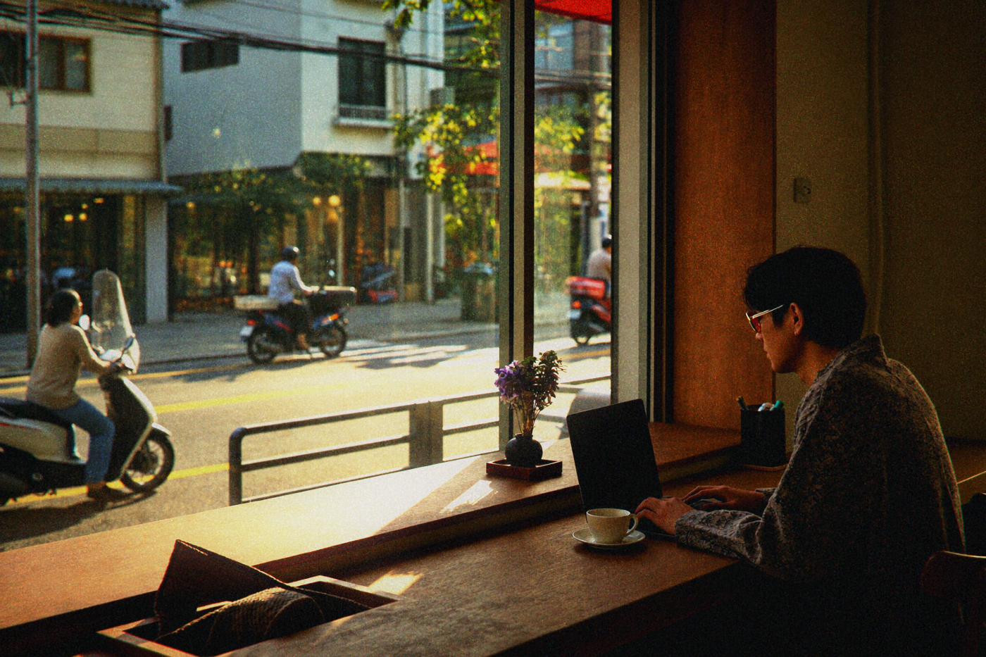Window seat at a Taipei cafe with a view of scooters and busy traffic outside