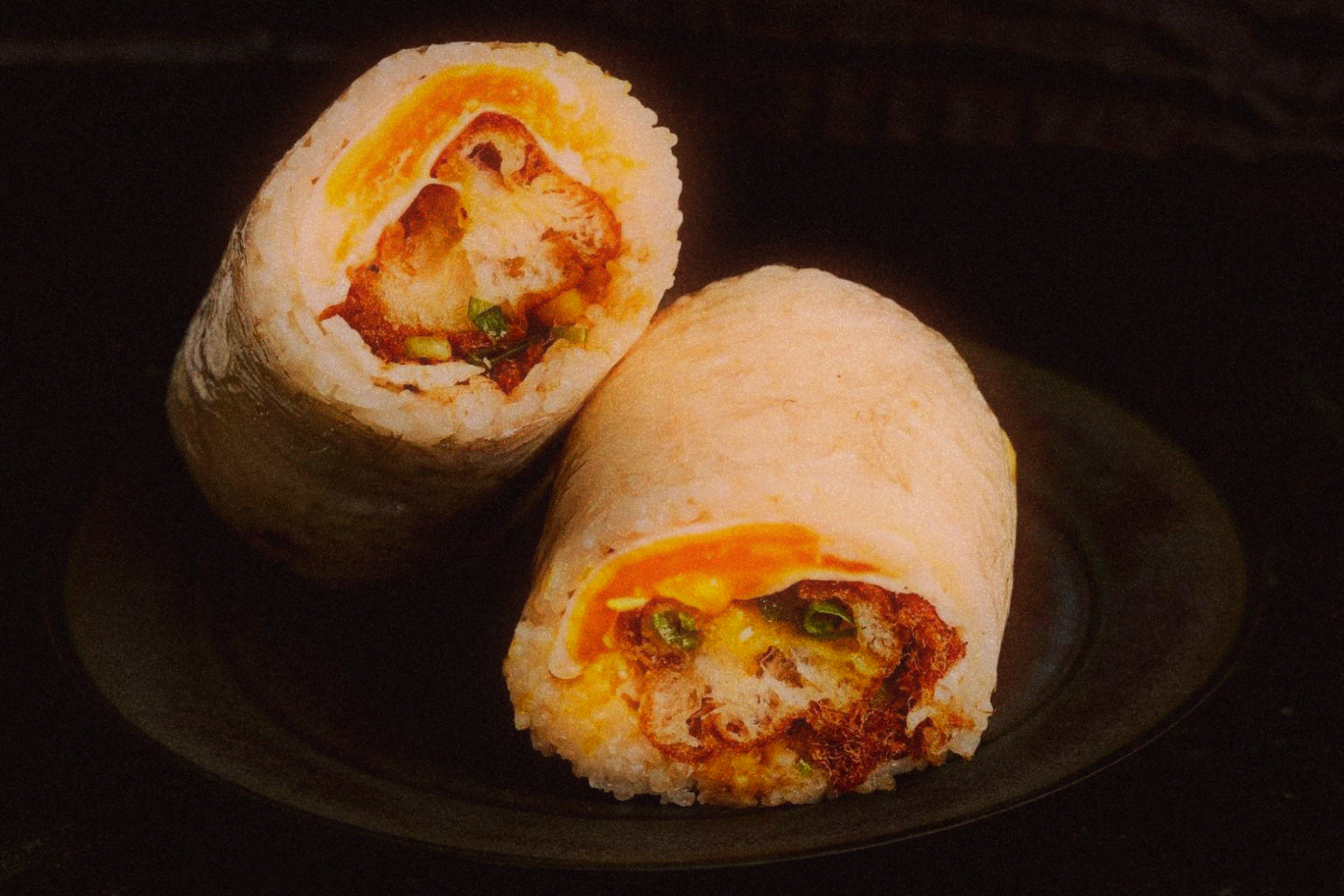 Taiwanese rice roll cut in half, showing fried cruller, egg and pickles inside