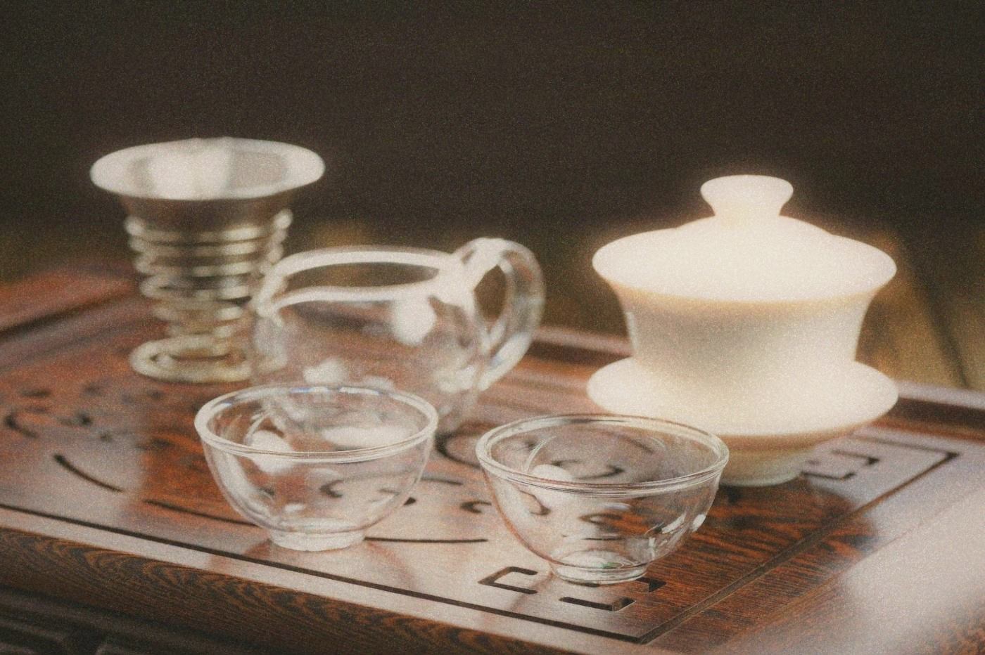 Close-up of ceramic tea cups and a gaiwan on a simple tray