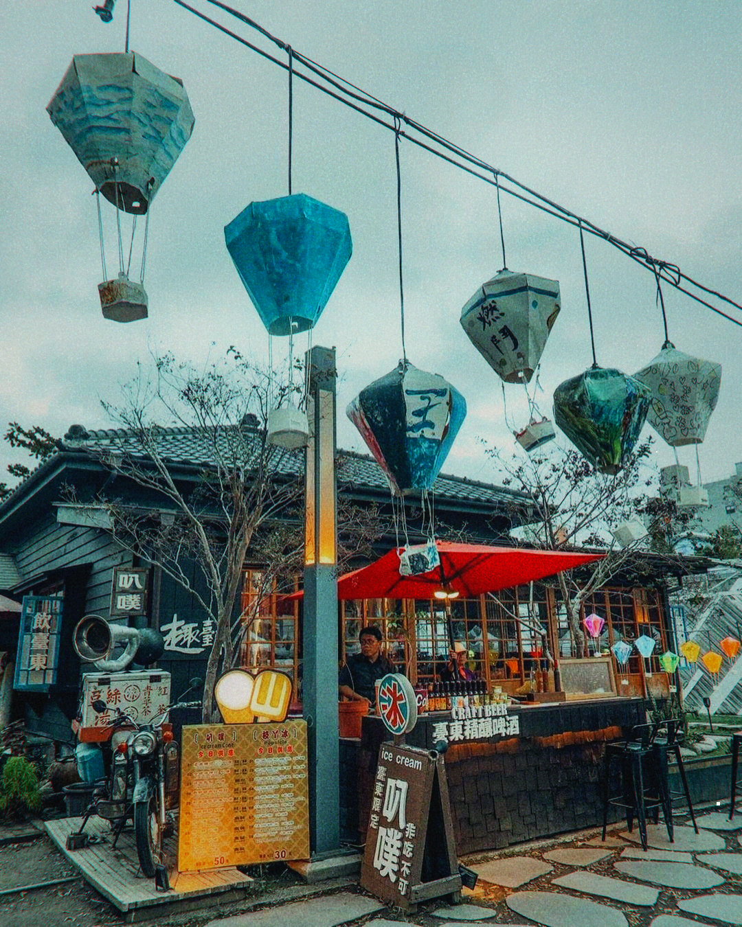 Evening scene at Tiehua Village with glowing lanterns and people gathered for live music