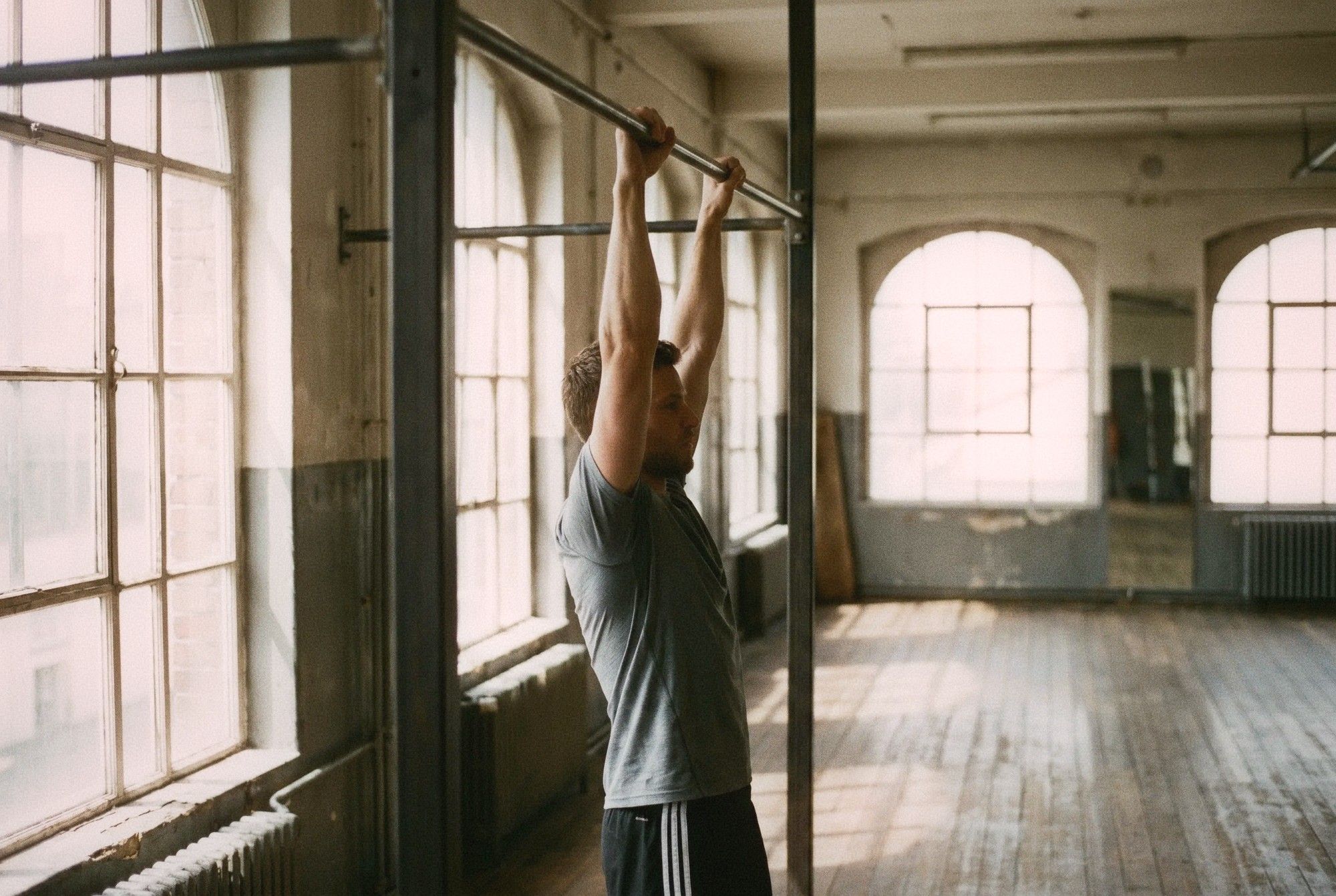 Man doing a dead hang from a pull-up bar