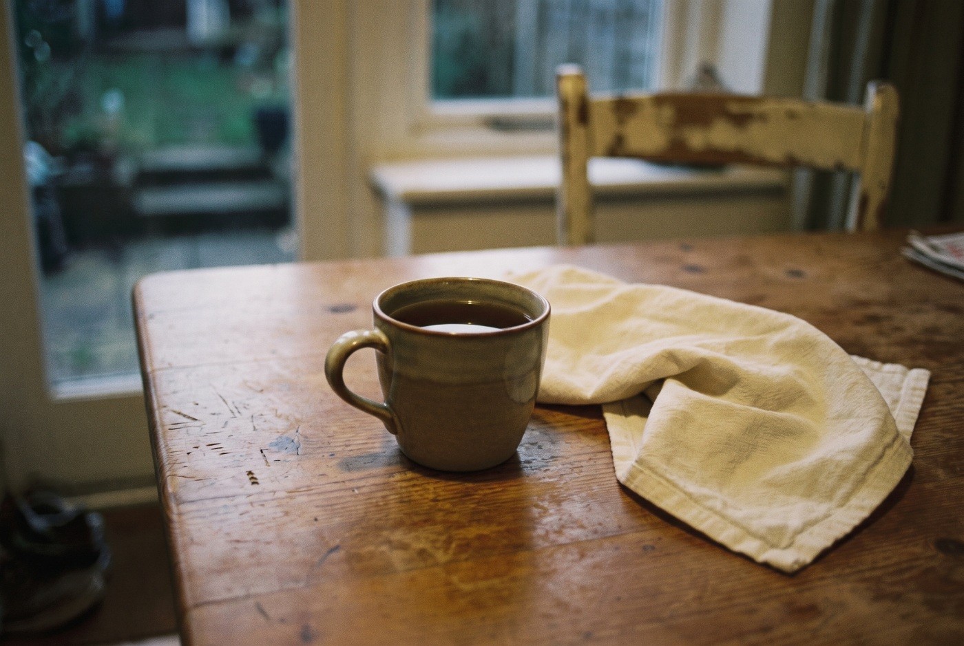 Illustration: A warm drink on a worn wooden table.