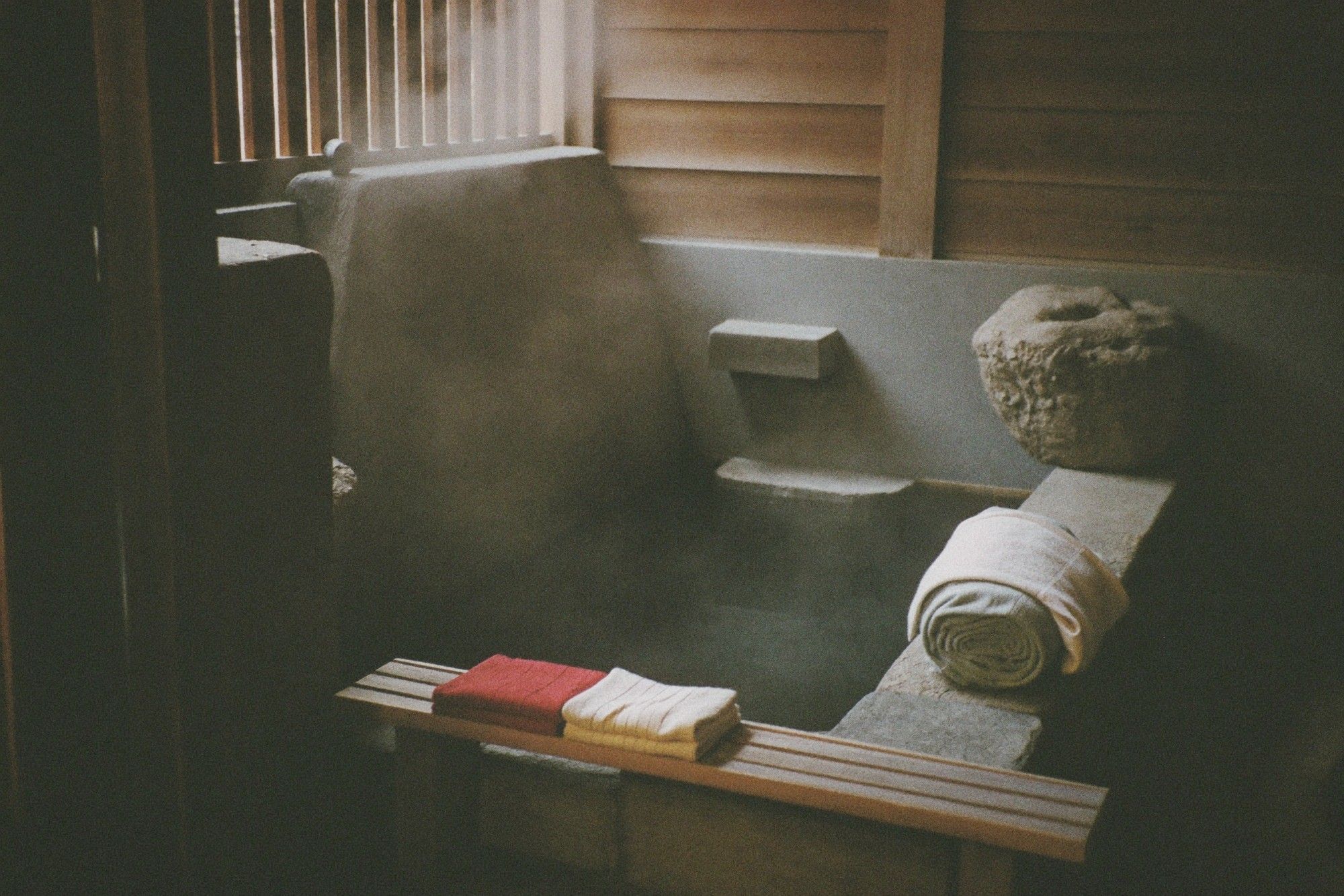Spa interior with rolled white towels and stone decor in a hot spring resort