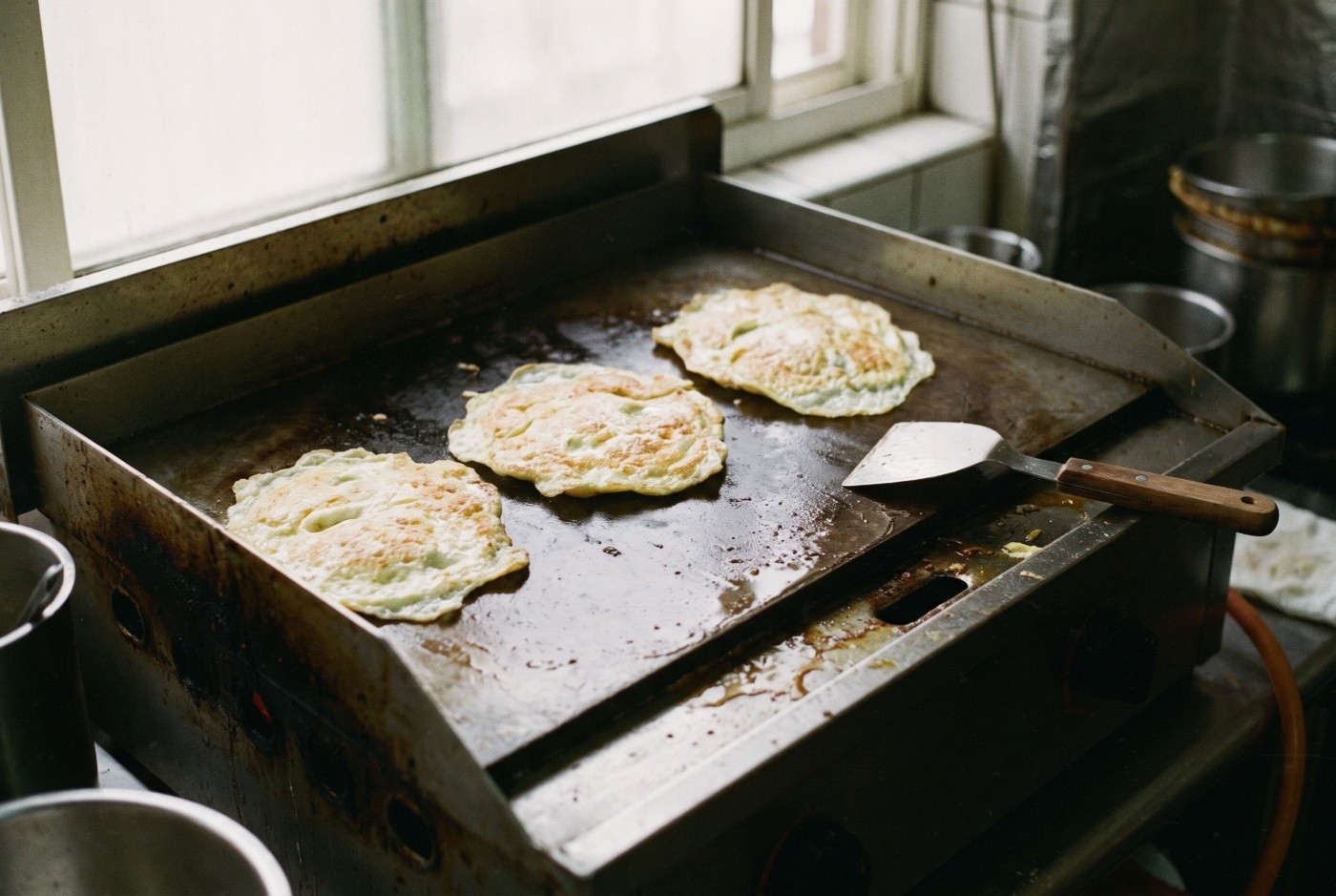 Illustration: Egg pancakes on a well-used griddle.