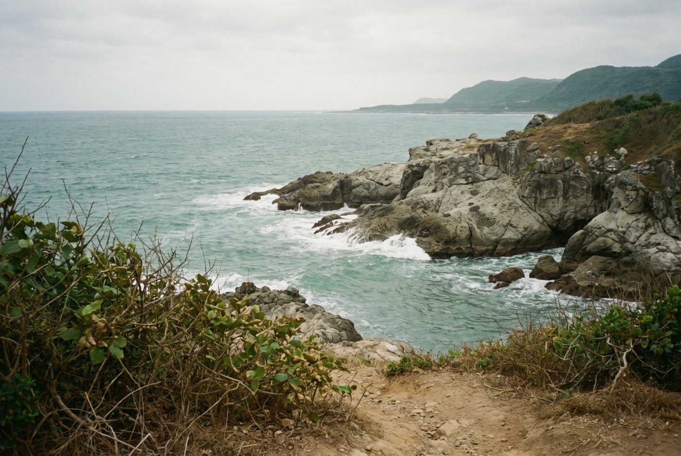 Illustration: A rocky coastline under soft grey skies.