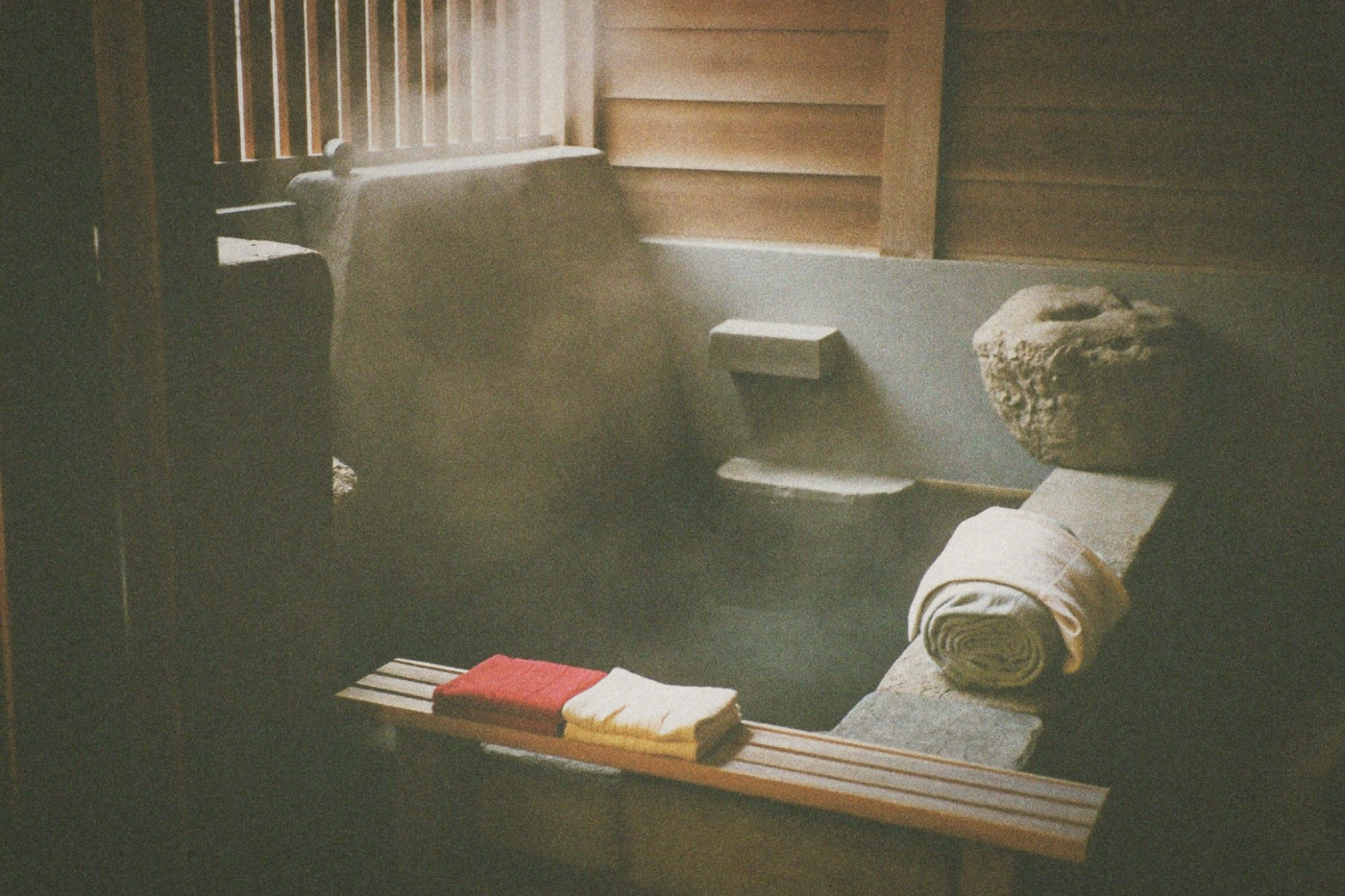 Spa interior with rolled white towels and stone decor in a hot spring resort