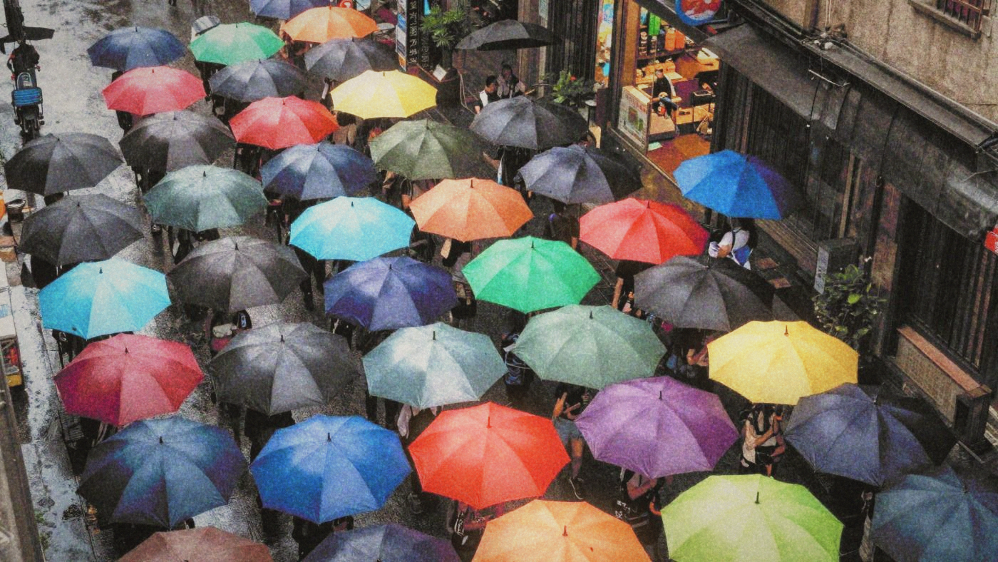 A sea of umbrellas from above on a crowded Taipei street during heavy rain