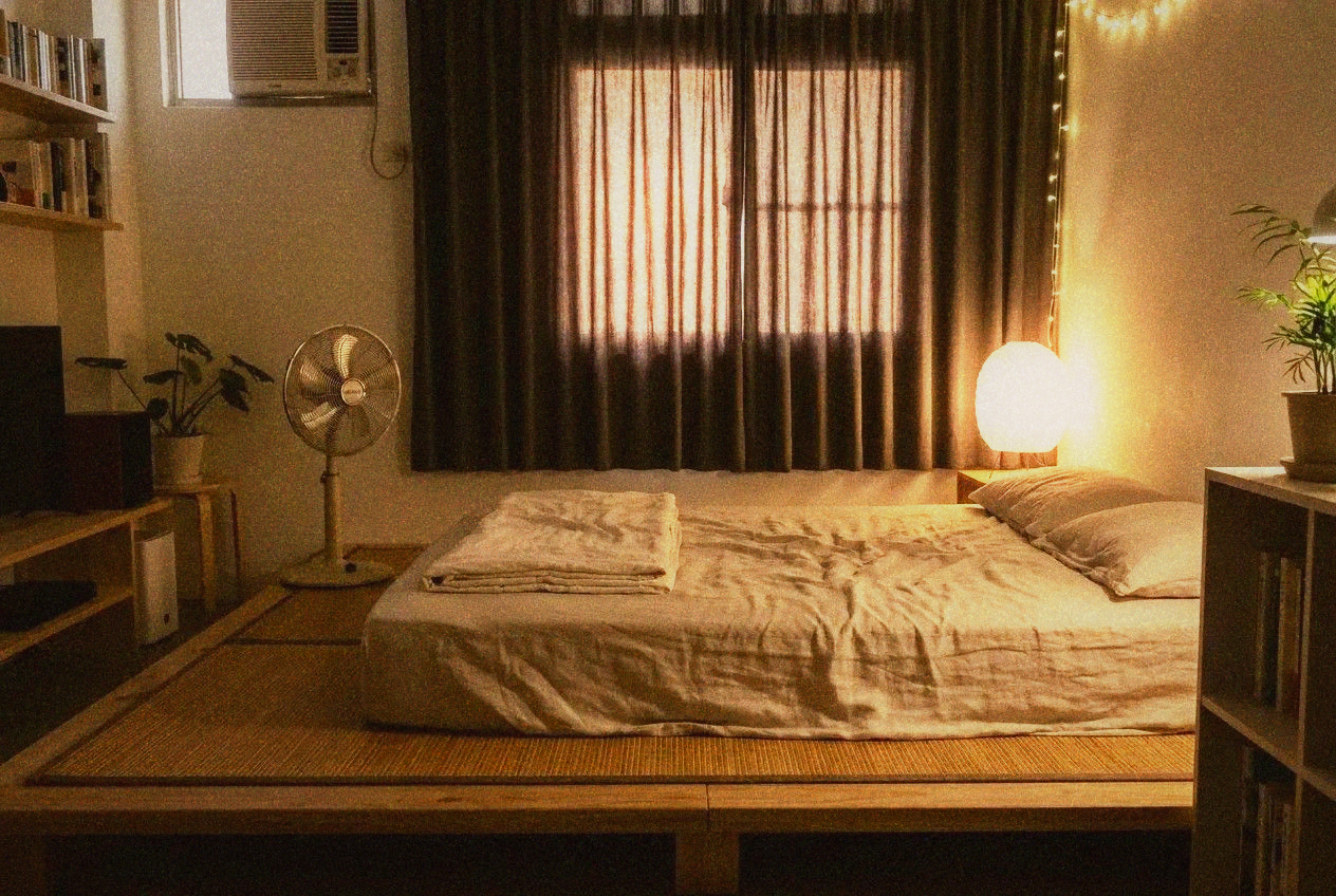 Comfortable Taipei bedroom set up for summer sleeping with bamboo mat and standing fan
