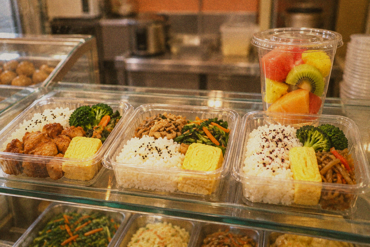 Refrigerated display cases in a Taiwan convenience store filled with bento boxes and fresh fruit