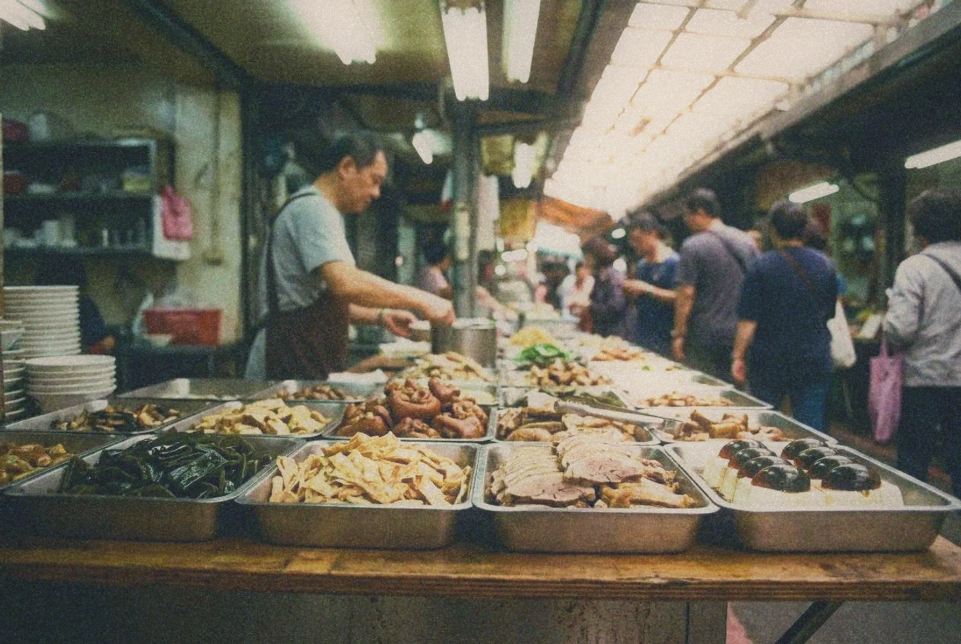 Market stall display of cold prepared vegetable dishes and tofu in metal trays