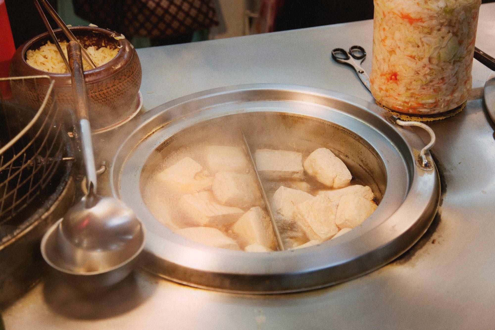 Steamed stinky tofu served in bamboo baskets with pickled vegetables