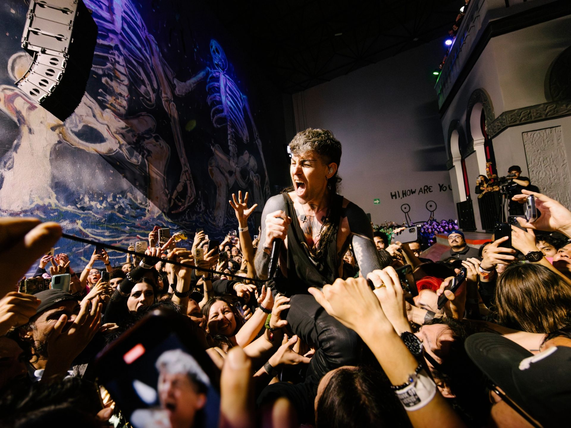 Davey Havok, vocalista de AFI haciendo crowd surfing y cantando sobre una masa de fans en concierto en vivo en Ciudad de México - Fotografía por Alan Cortés
