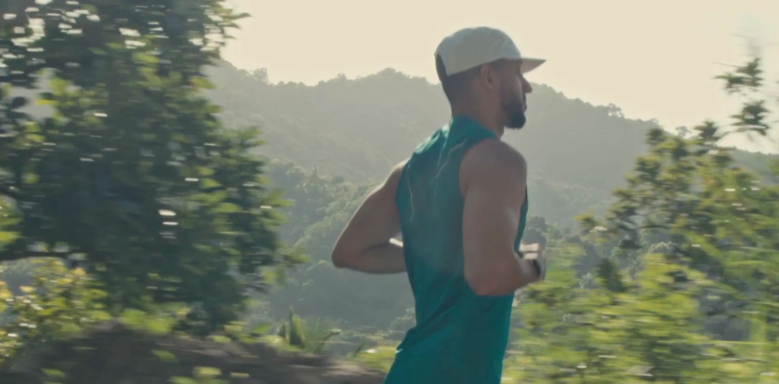 Runner wearing the white PAUER HATS cap during a morning trail run
