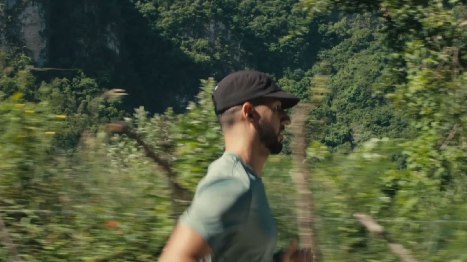 Runner on a mountain trail wearing a black PAUER HATS performance cap