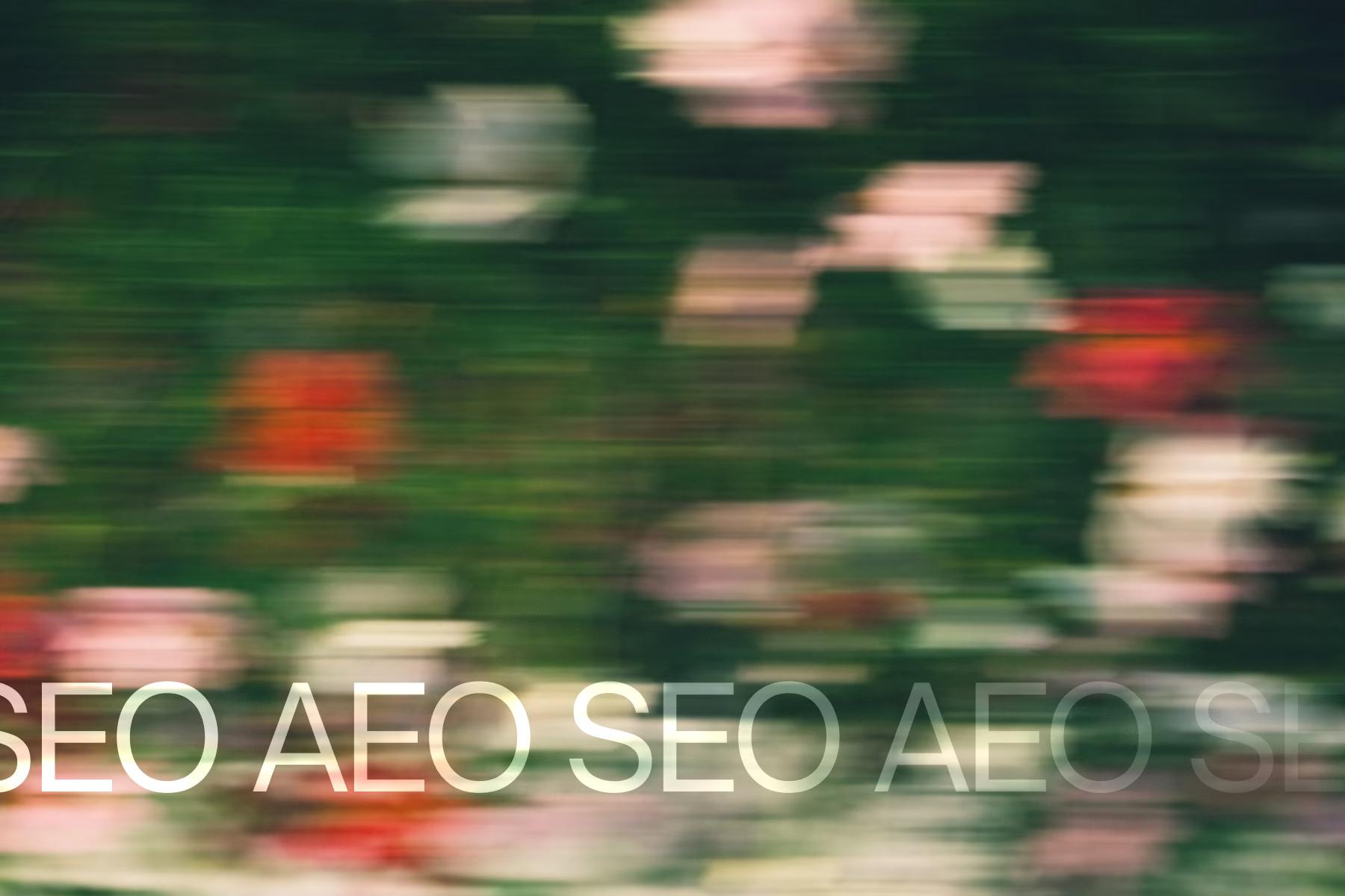 Schriftzug «SEO AEO» vor verschwommenen Blumen
