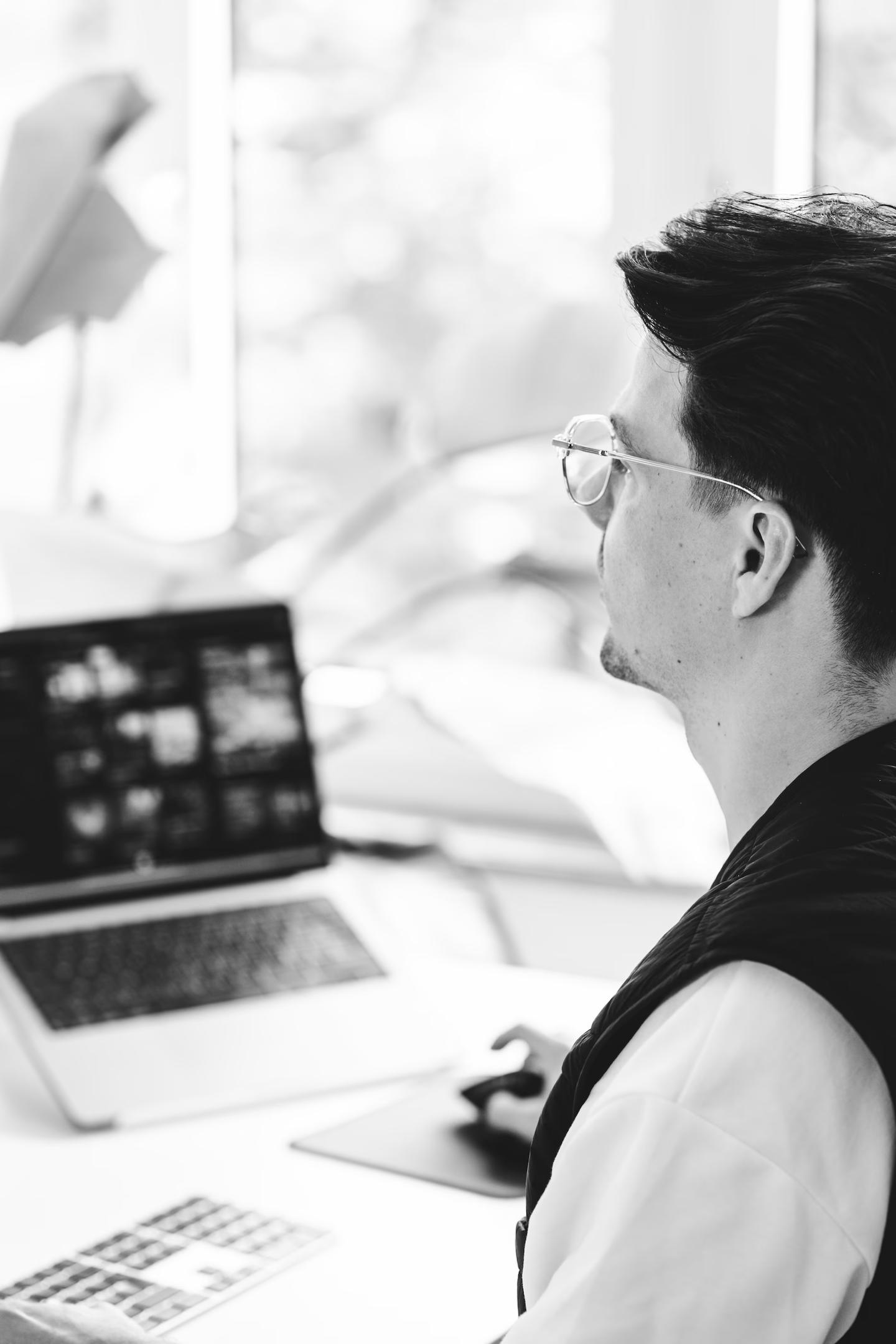 Patrick Hux arbeitet am Laptop, in Schwarzweiss