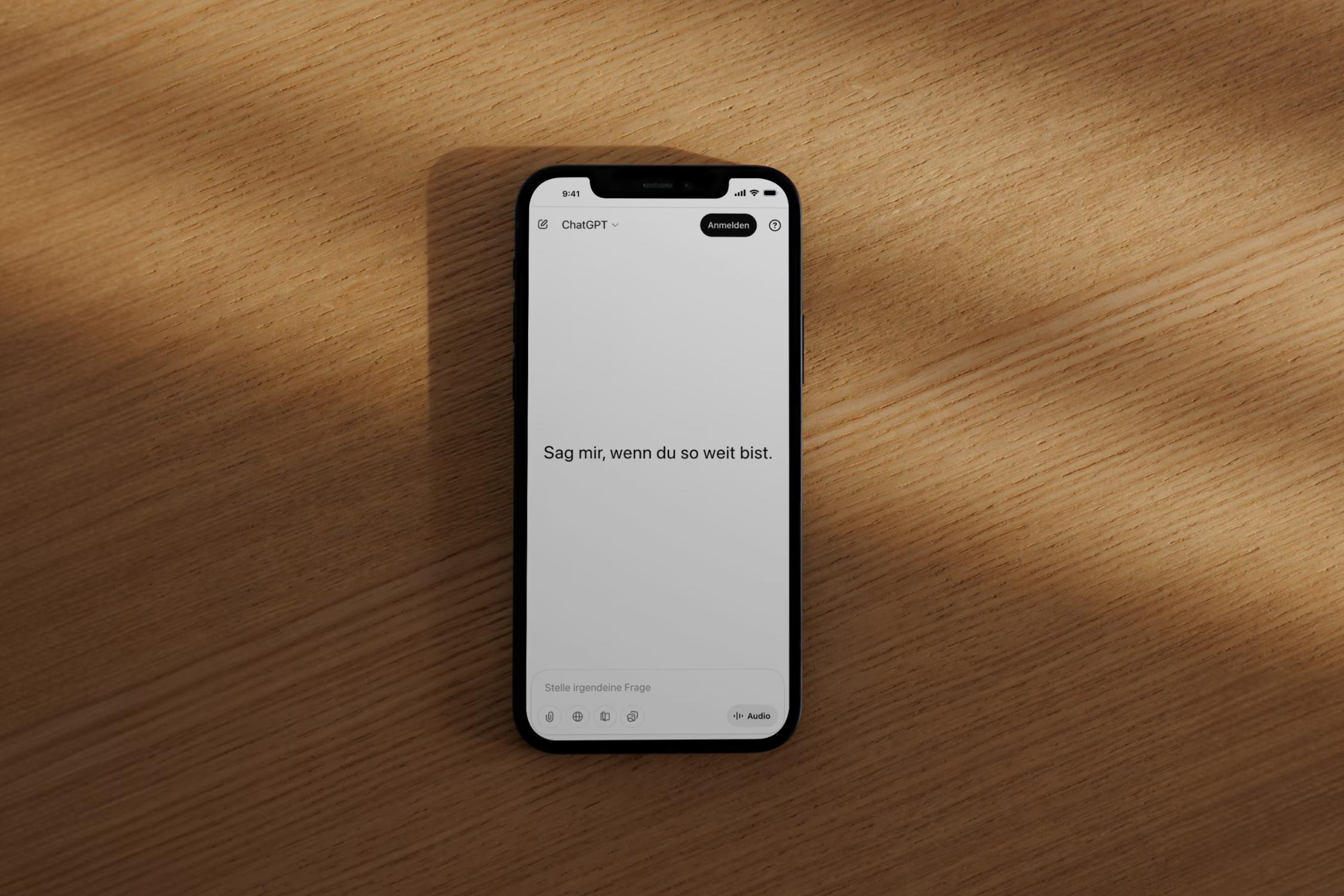 Smartphone mit ChatGPT auf einem Holztisch
