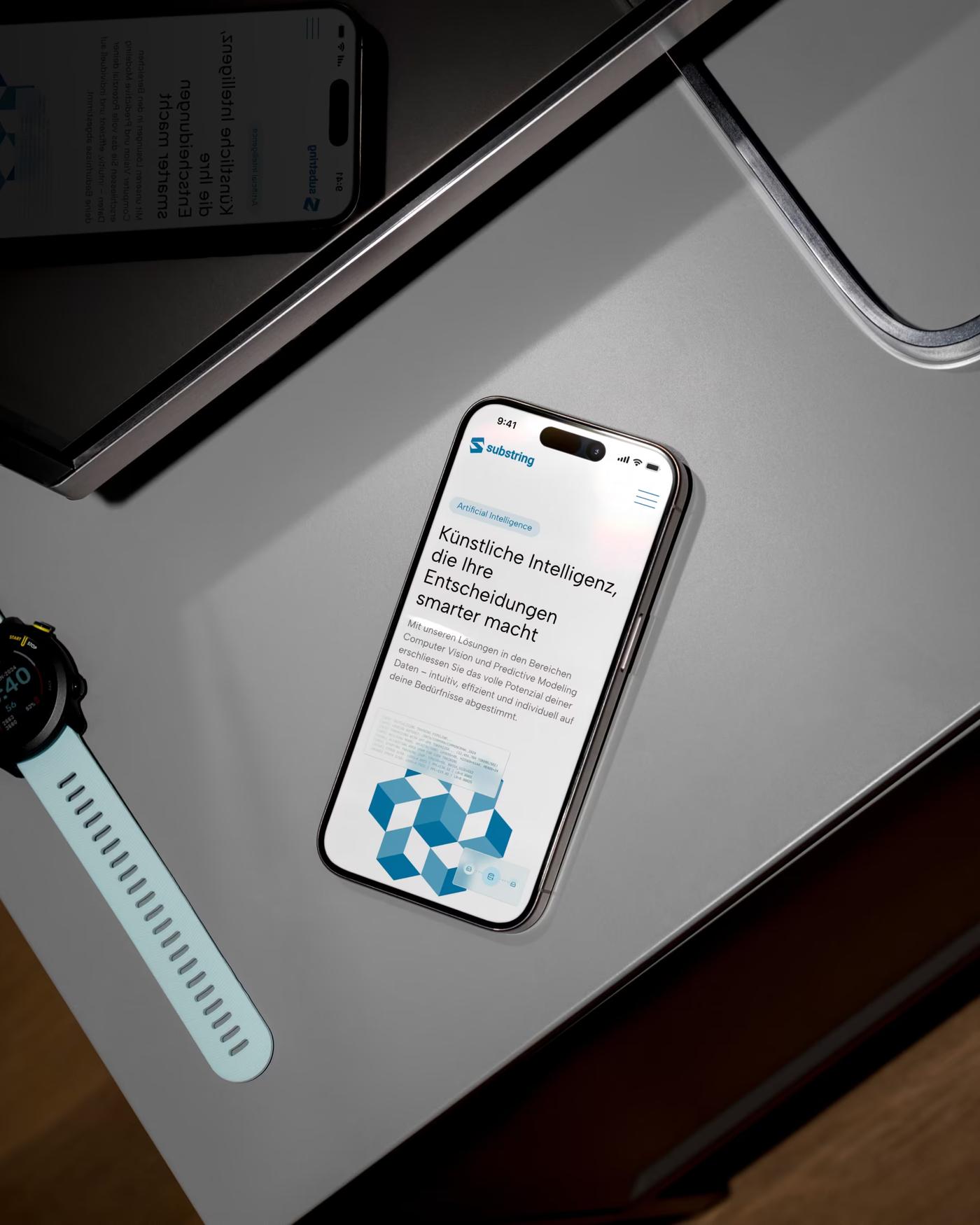 Smartphone mit der Seite «Künstliche Intelligenz» von Substring, daneben eine Smartwatch