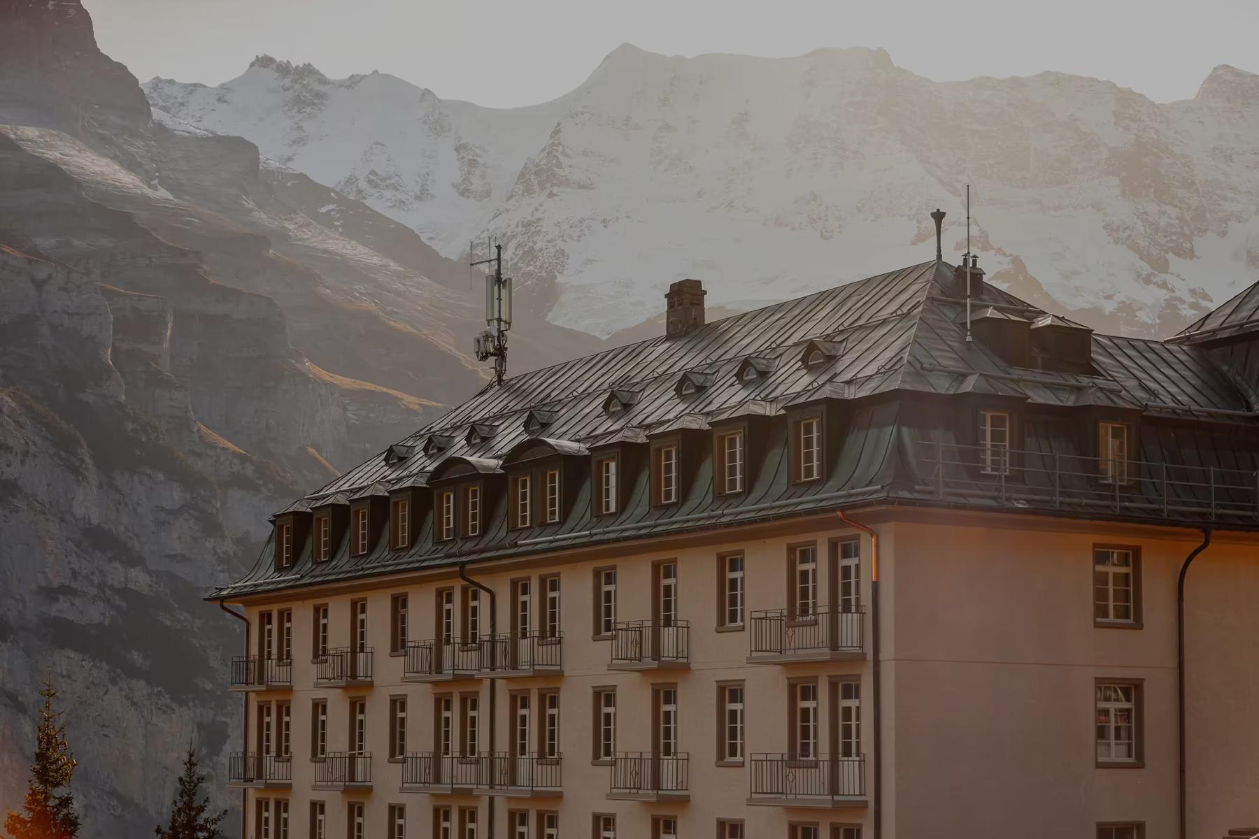 Historisches Hotelgebäude vor Berggipfeln