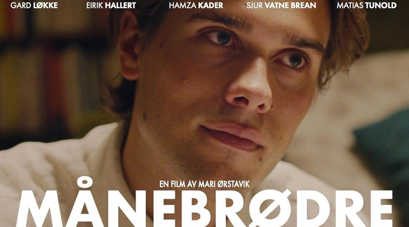 En mann i hvit skjorte titter til siden