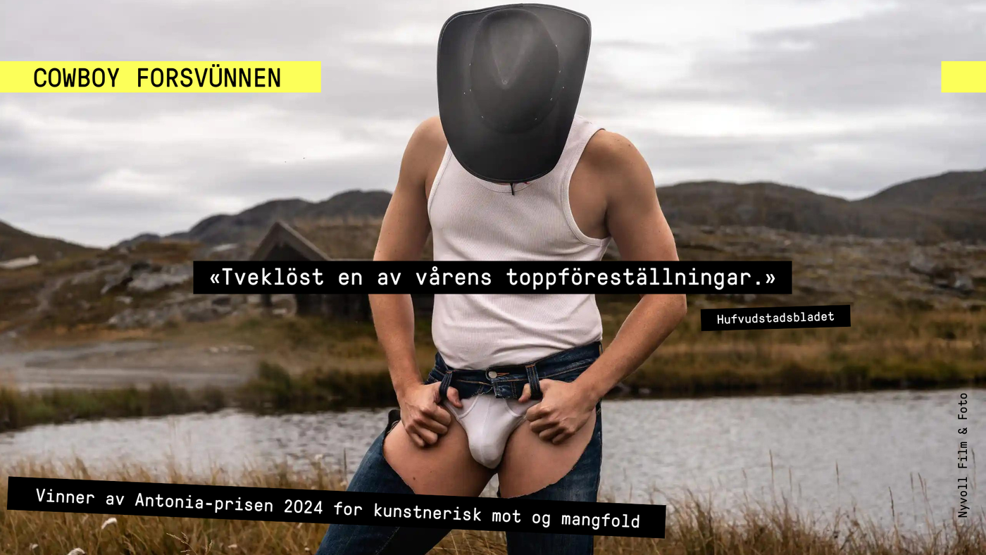 Mann i hvit tank topp, hvit truse og chaps står med bøyet hodet. Vi ser toppen på cowboyhatten hans. Bak han ser man et fjelllandskap, en hytte med gress på taket og et lite vann. 