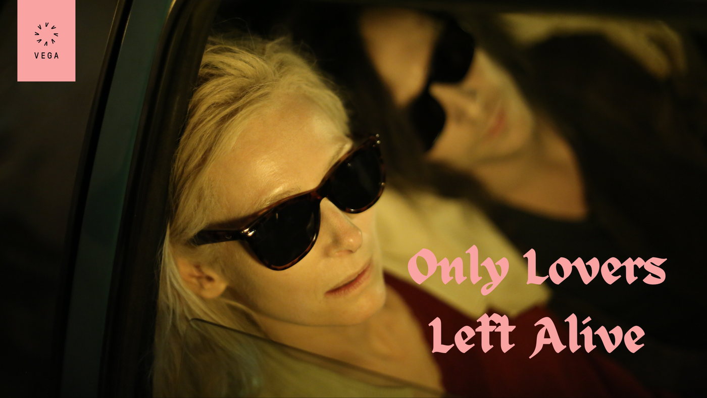 En kvinne og en mann inne i en bil. Begge har solbriller på og kan se ut som de sover eller hviler