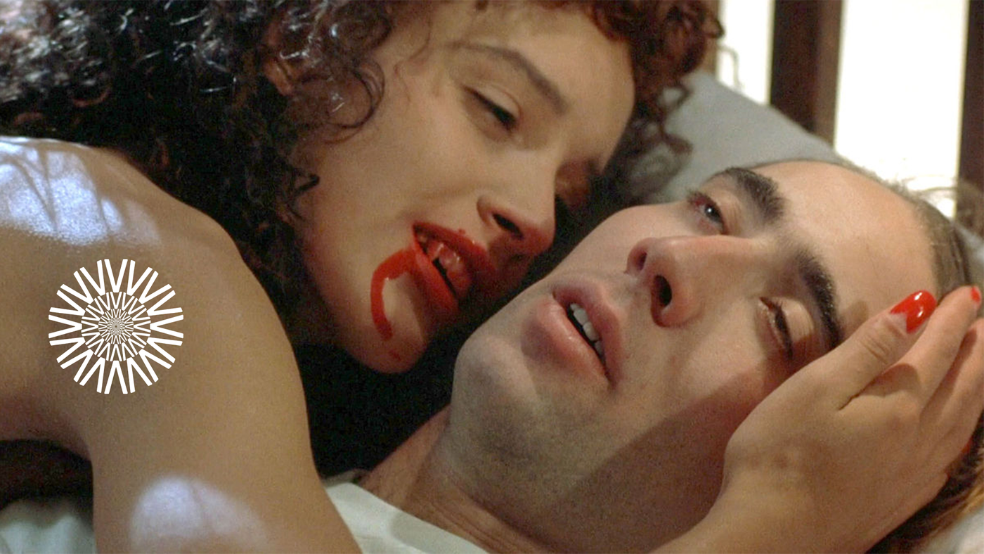 et nærbilde av en vampyrkvinne som berører ansiktet til en nesten død mann