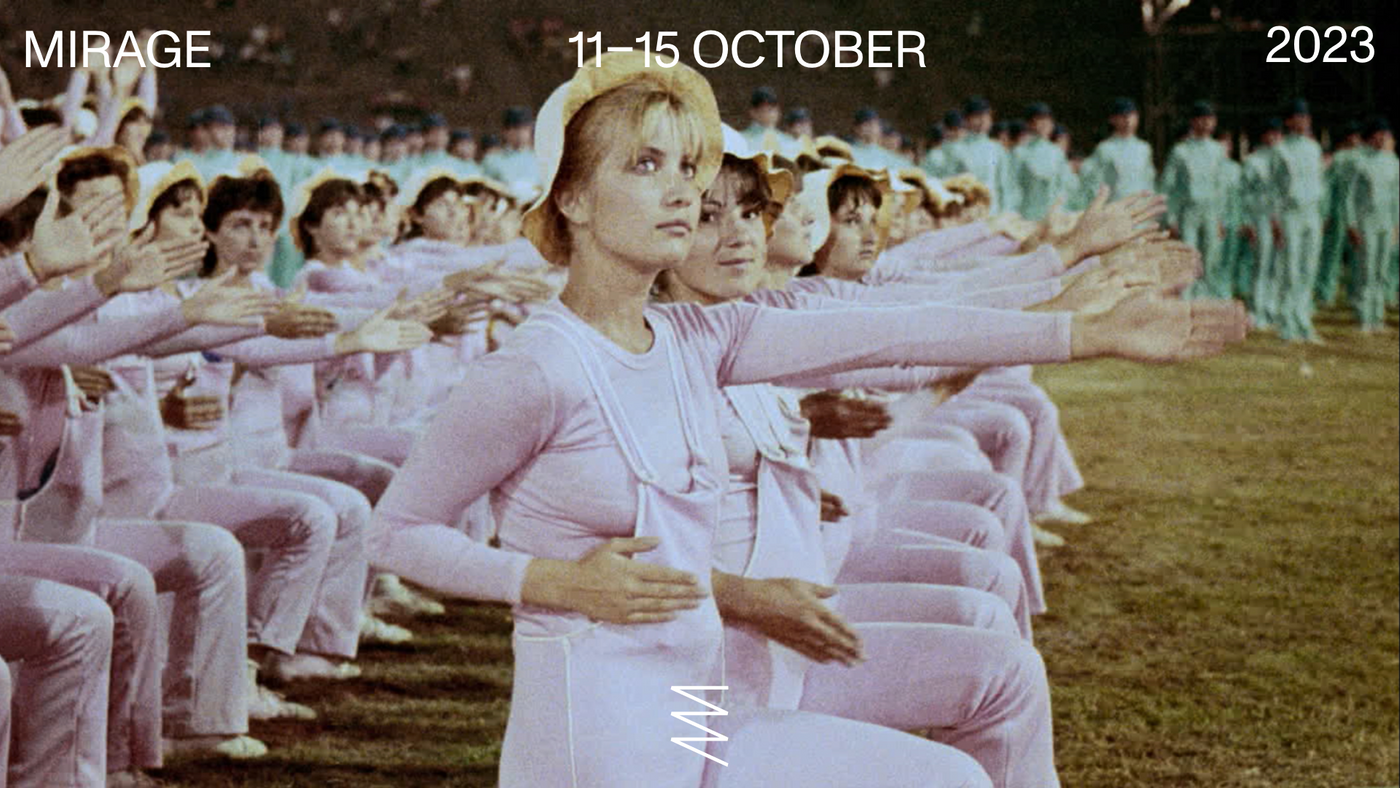 Flere kvinner i matchende rosa bevegelig tøy gjør samme øvelsen på rekke og rad.