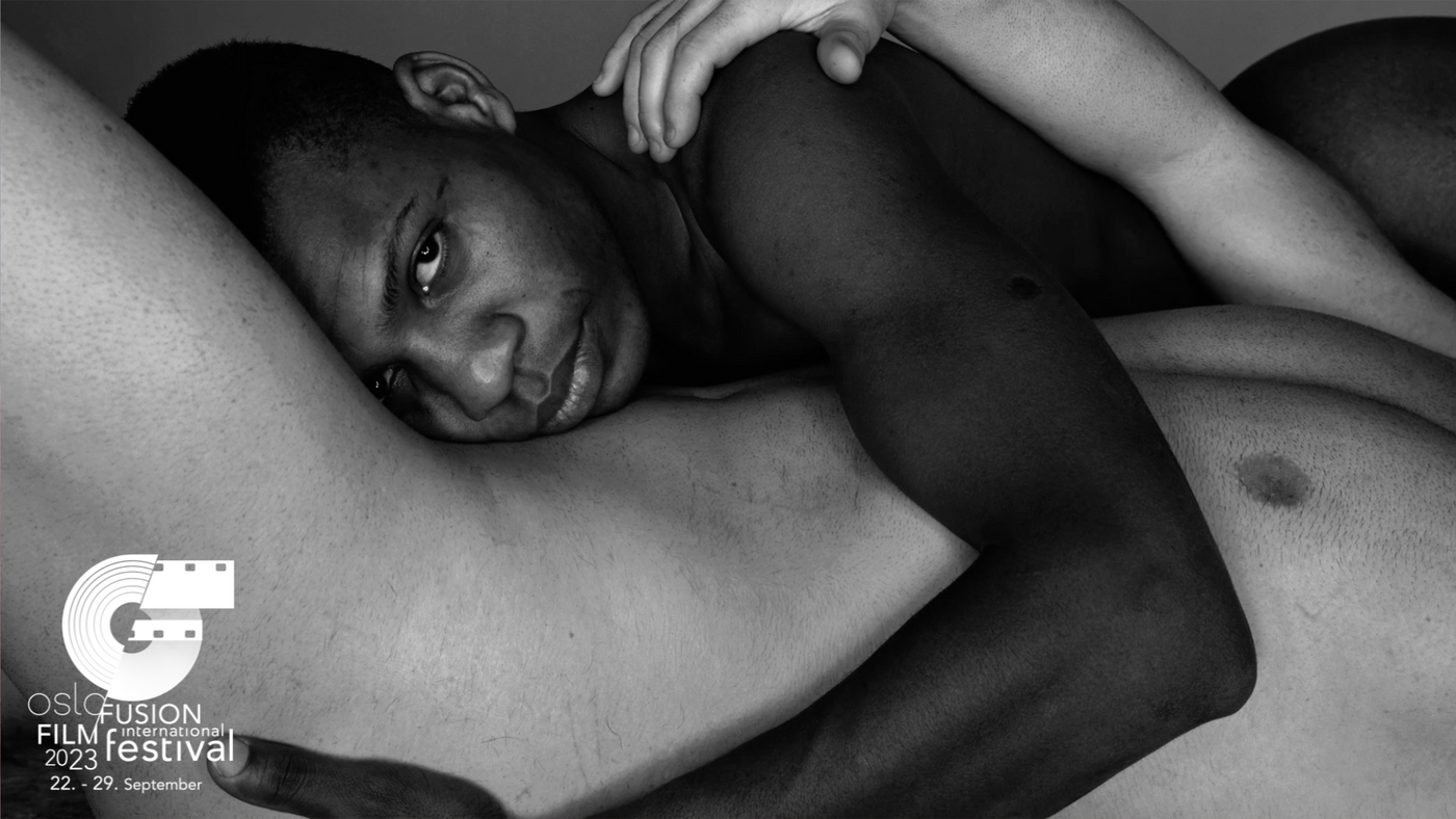Et svart-hvitt bilde med to nakne menn som holder hverandre liggende.