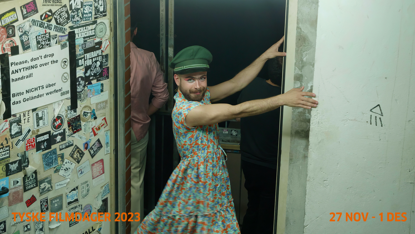 En mann i kjole står i en døråpning
