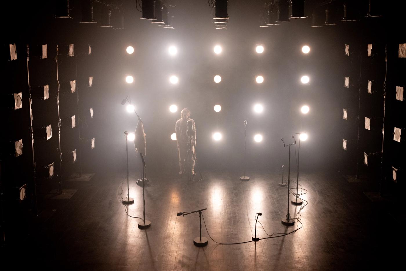 Fredrik med lys rundt om seg. En rekke mikroner i rommet.