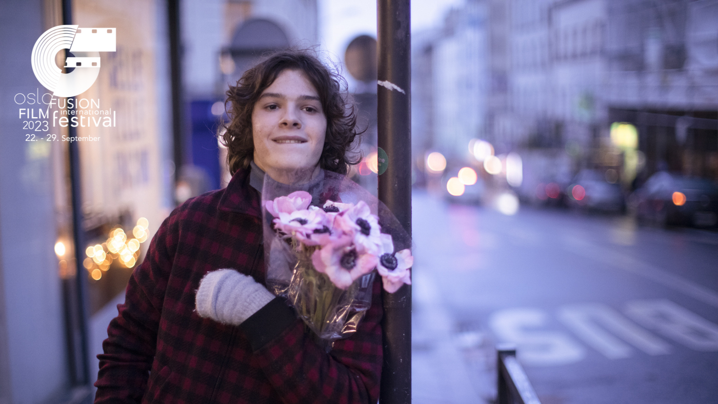 En ung gutt med en blomsterbukett i armene