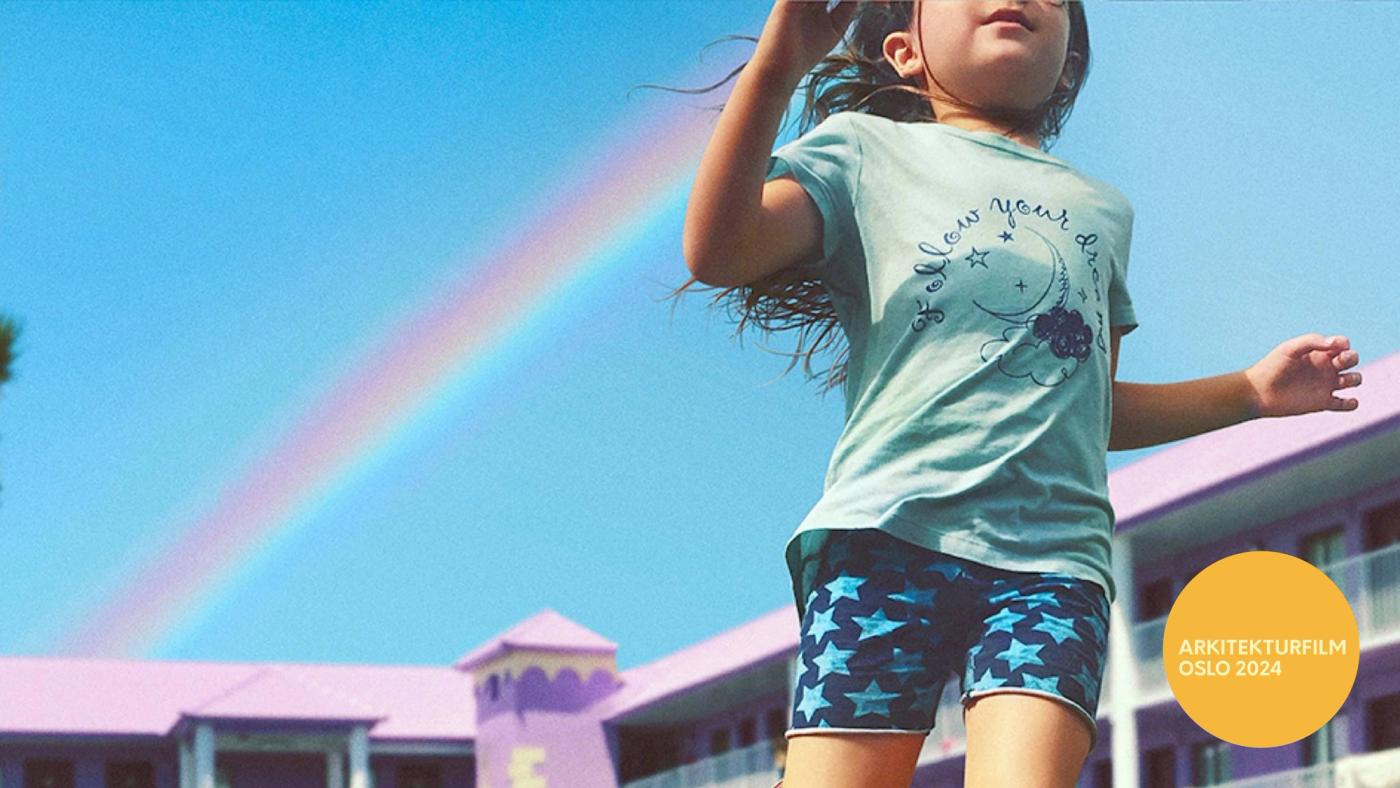 En liten jente løper med regnbue bak