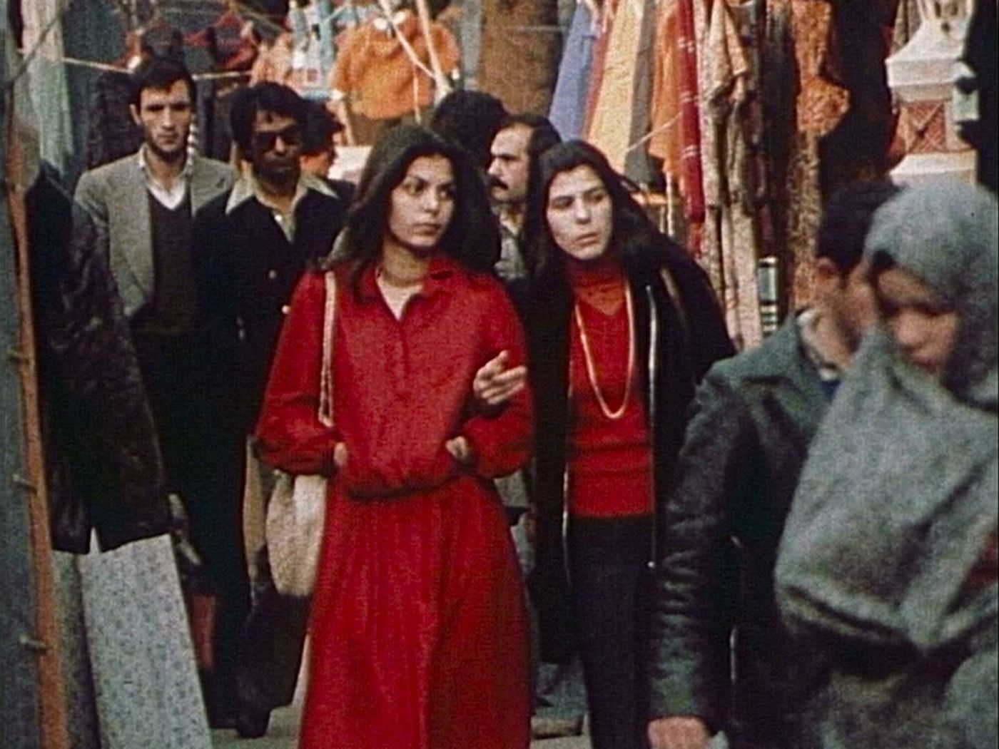 To kvinner og andre mennesker går gjennom et marked.