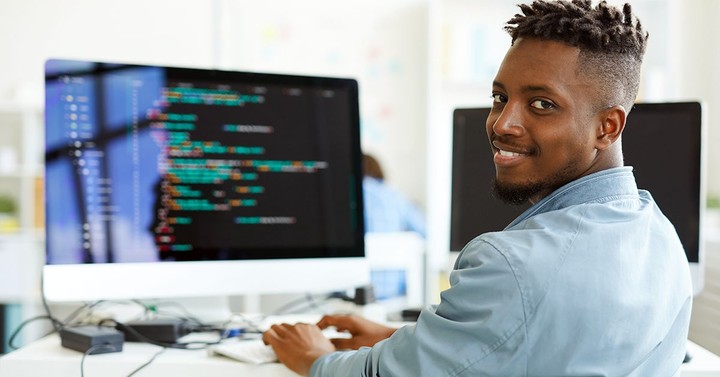 Illustration of a developer at a coding workstation exploring six side income revenue streams