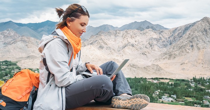Illustration of a travel blogger with passport, camera, and laptop earning income on the road