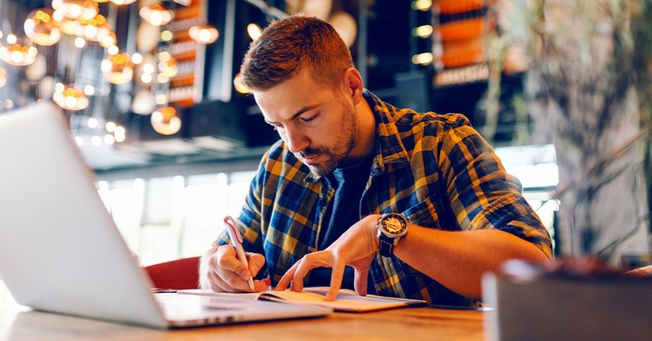 Illustration of a writer drafting a blog post at a desk with growth charts nearby