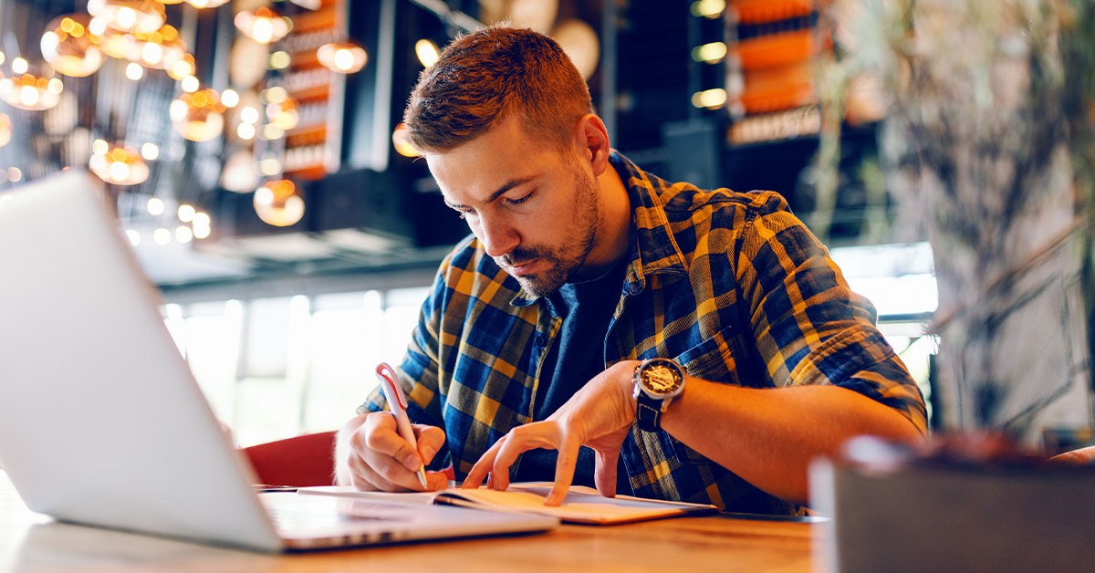 Illustration of a writer drafting a blog post at a desk with growth charts nearby