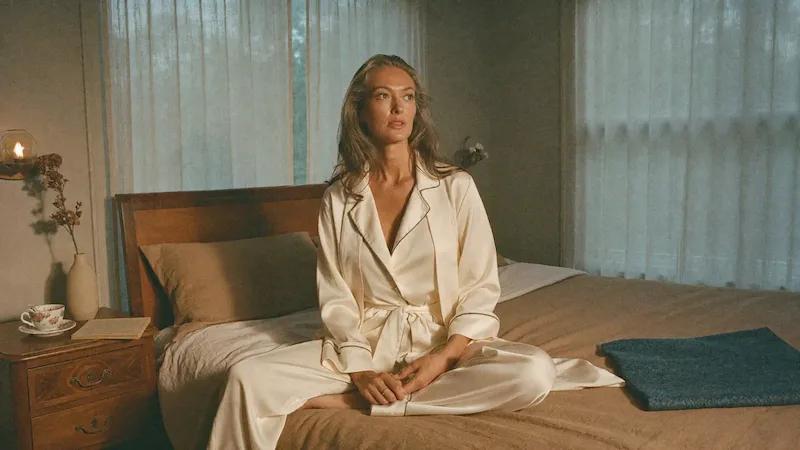 Entspannte Frau im Bett als Symbol für intimes Wohlbefinden und Schutz in den Wechseljahren