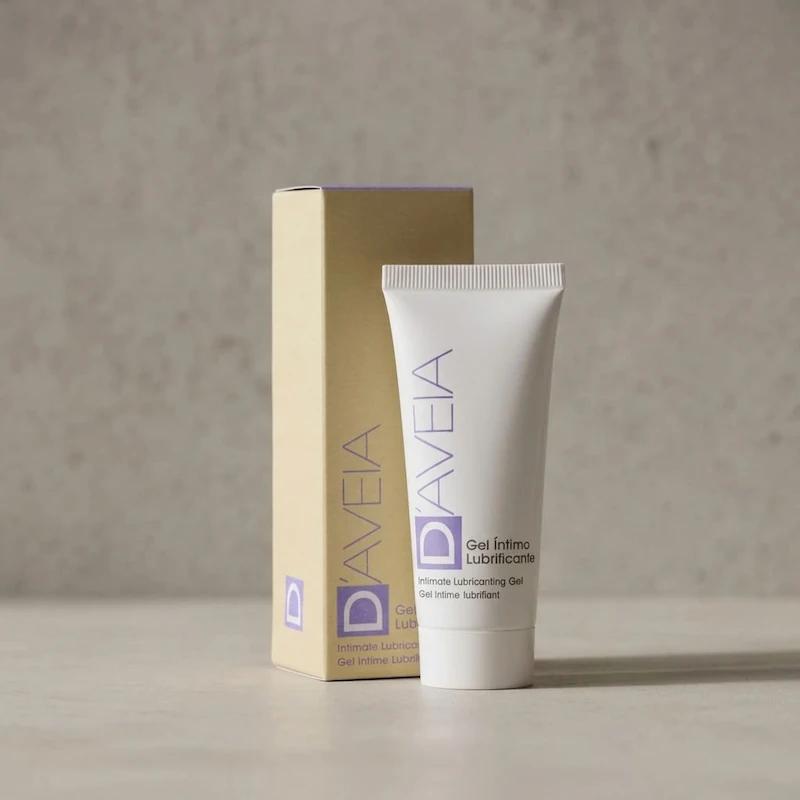 Weiße Tube D'AVEIA Intim-Gleitgel stehend direkt vor der schlichten, beigefarbenen Originalverpackung auf einem hellen, neutralen Untergrund.