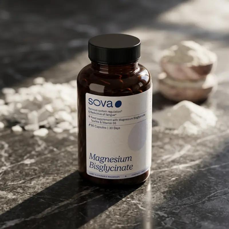 Sova Magnesium Bisglycinate Dose auf einer dunklen Marmoroberfläche mit weißem Pulver im Hintergrund