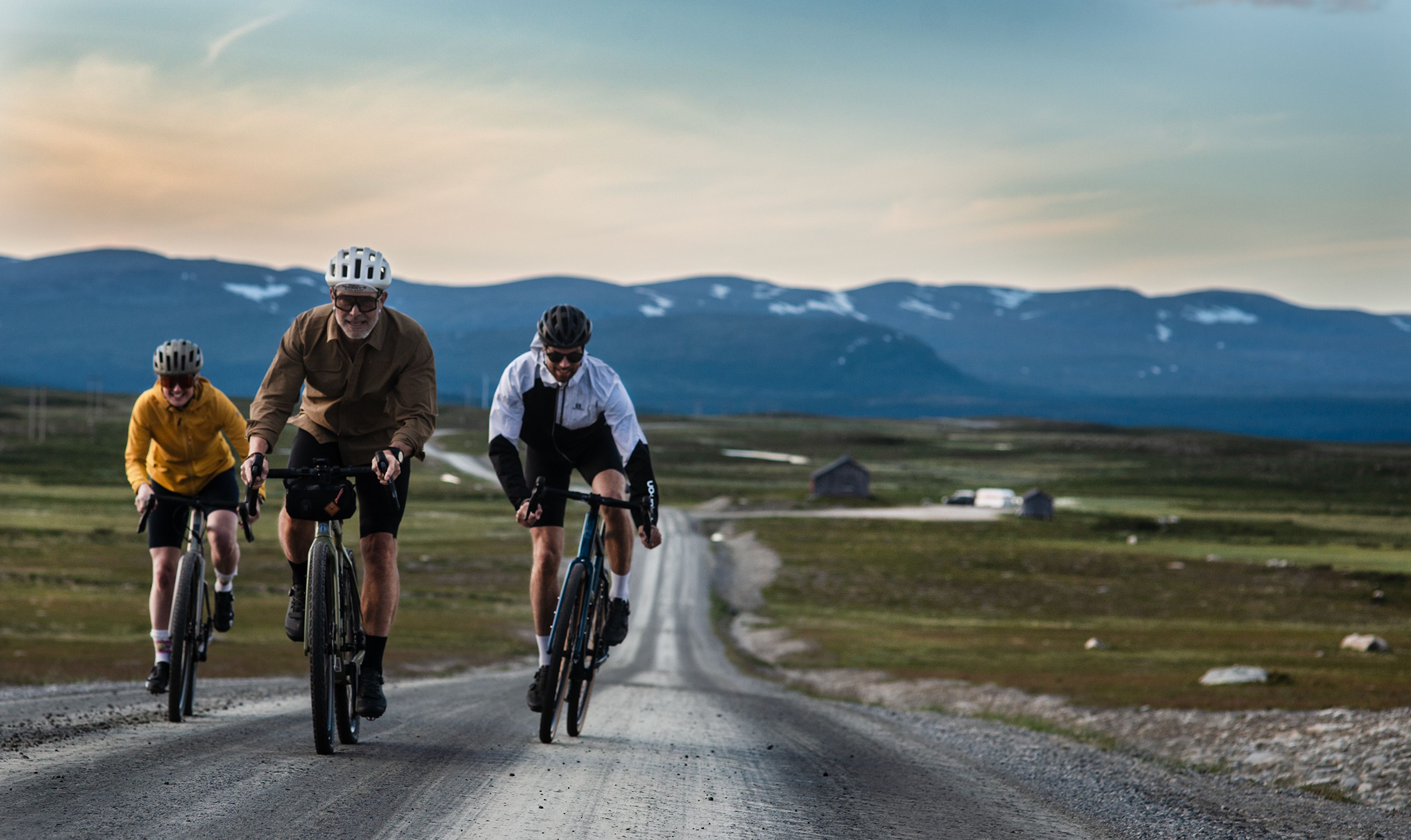 En grupp människor som cyklar gravel längs en grusväg.