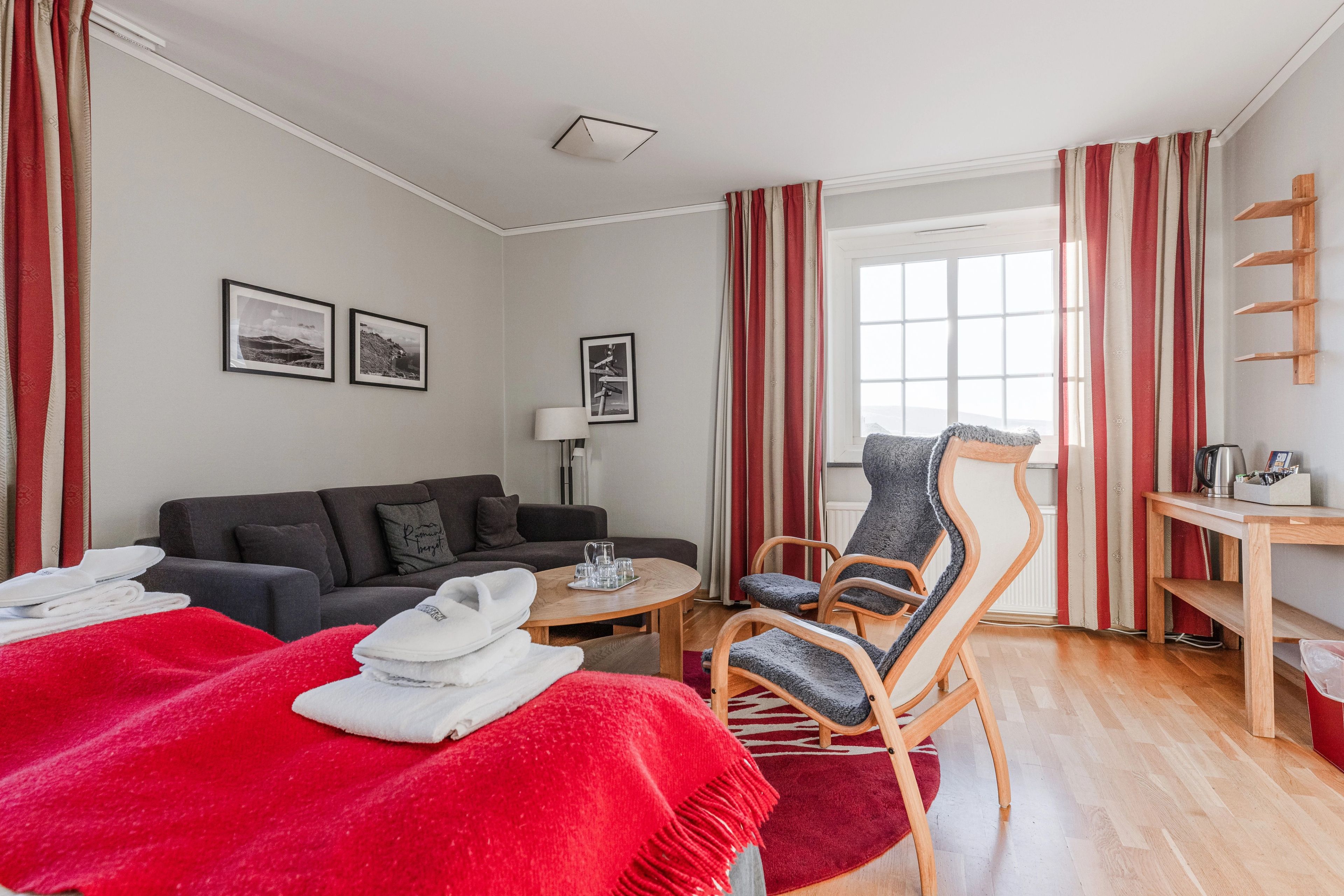 Ett hotellrum med en soffa, en fåtölj och en dubbelsängsäng.