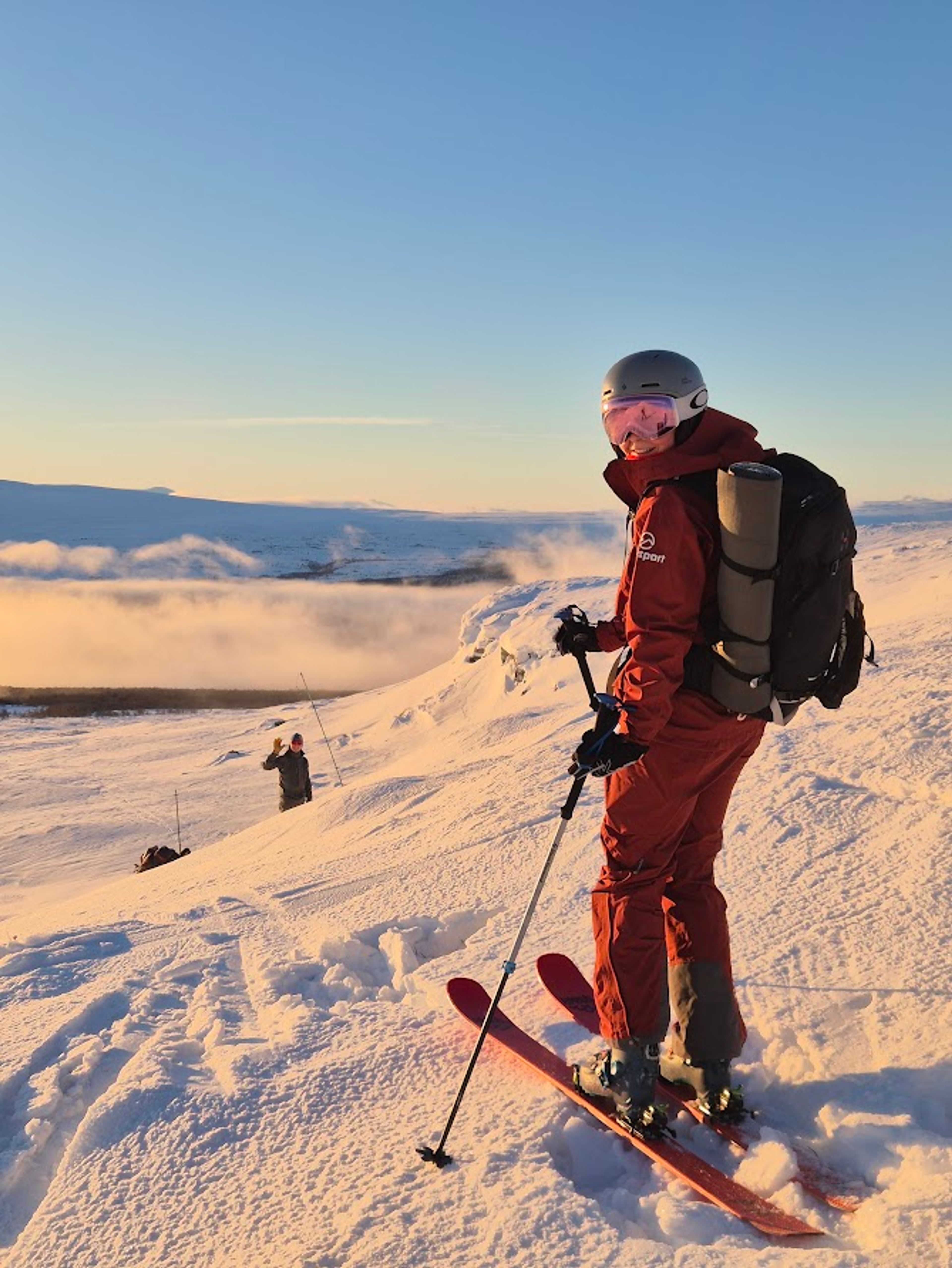 En person på skidor som står på en fjälltopp.
