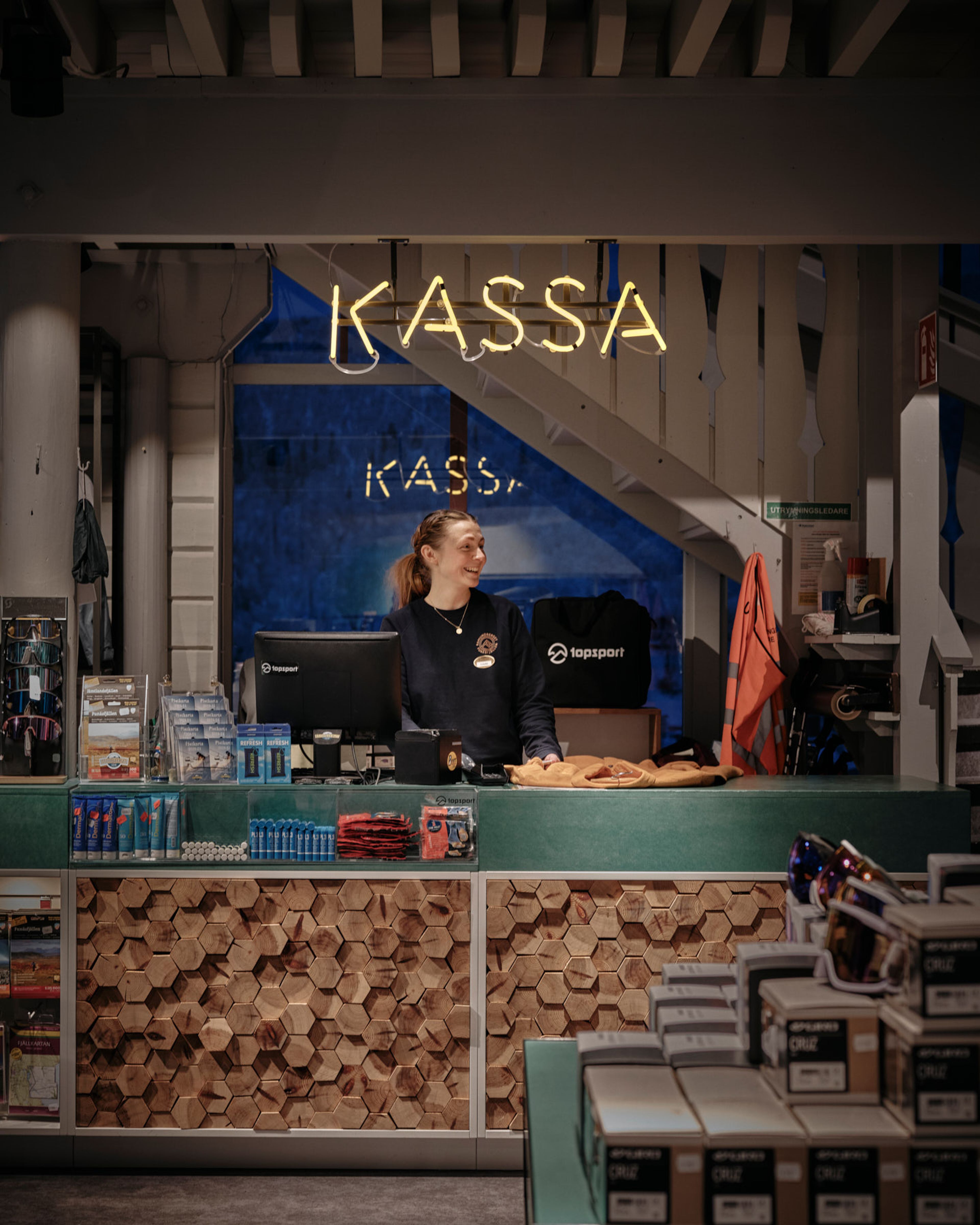 En kvinna som står bakom disken i en butik.
