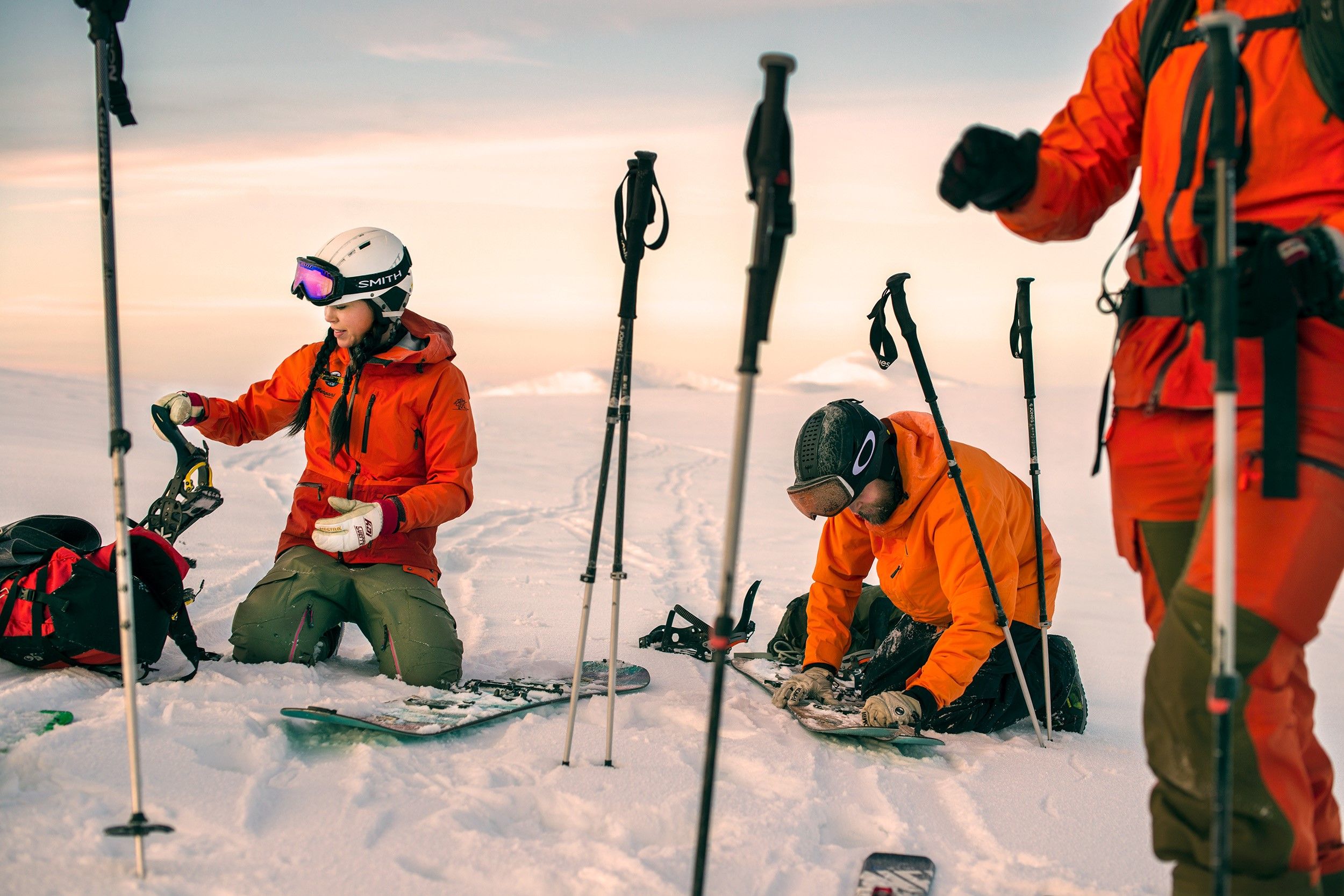 En grupp snowboardåkare som fixar utrustningen uppe på fjället.