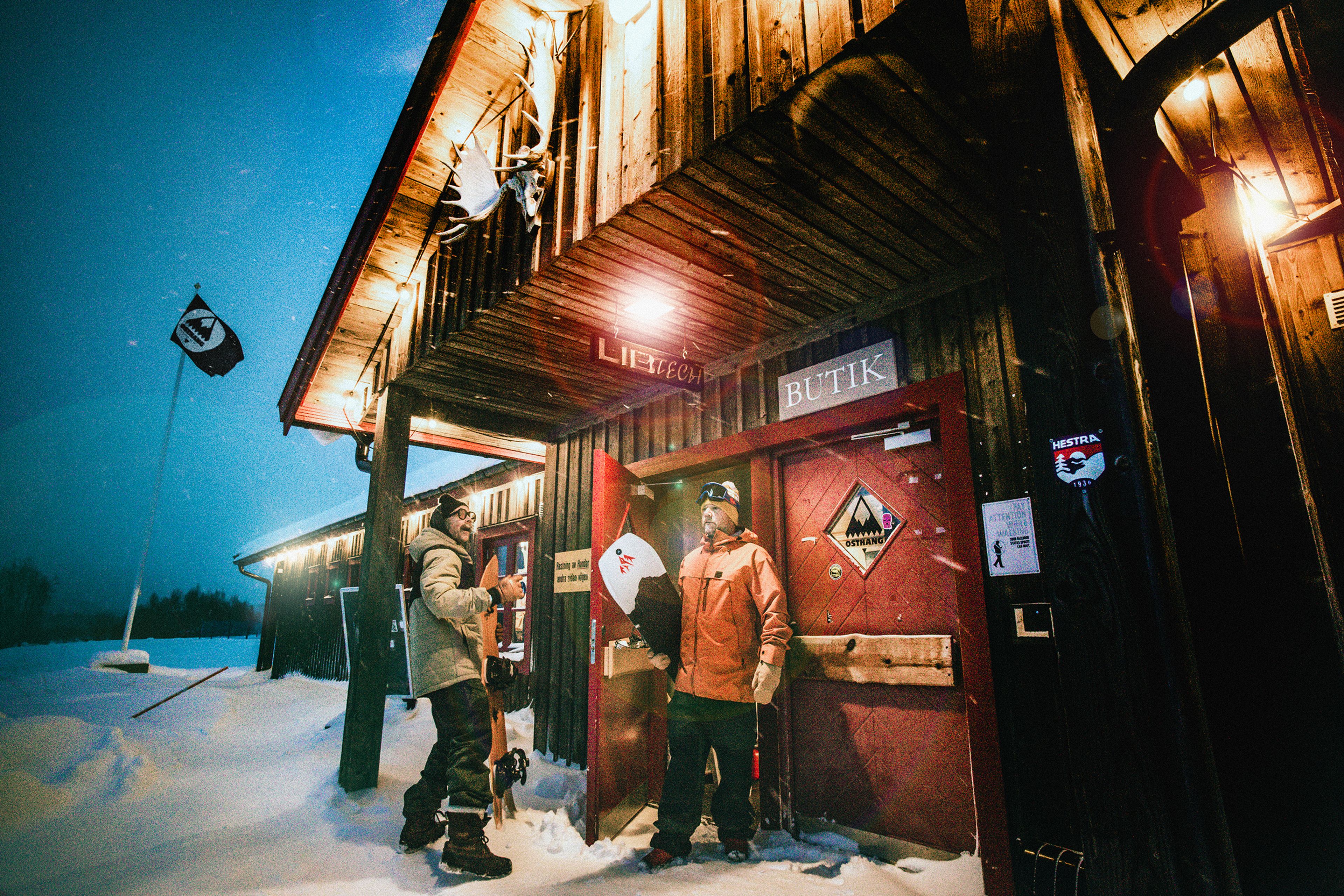 Två snowboardåkare som står utanför en butik.
