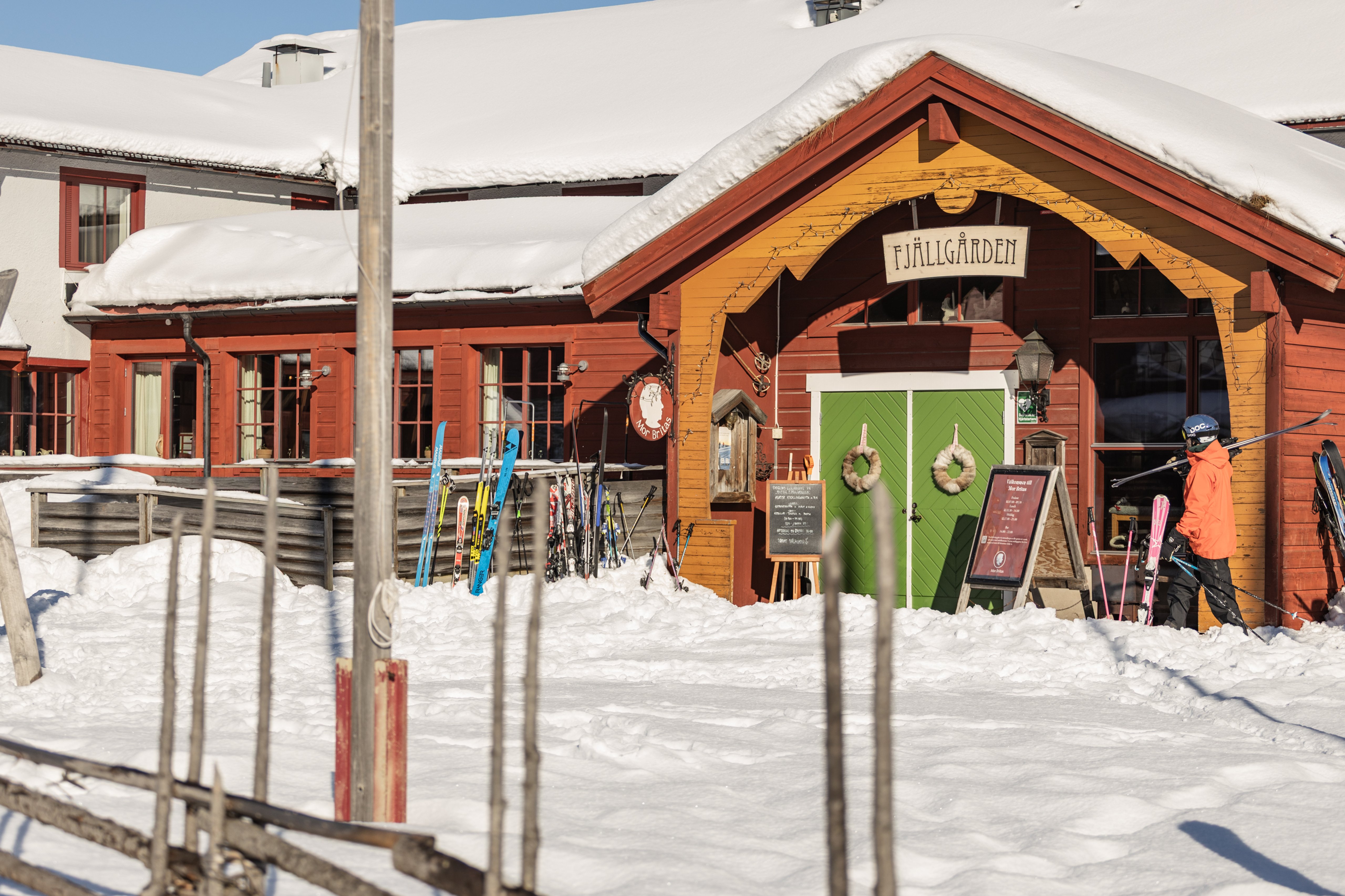 Ett fjällhotell som lyser upp i snön i mörkret.