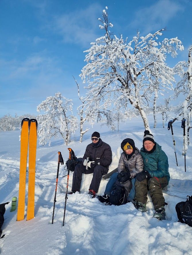 En grupp människor som sitter på toppen av ett snötäckt fjäll